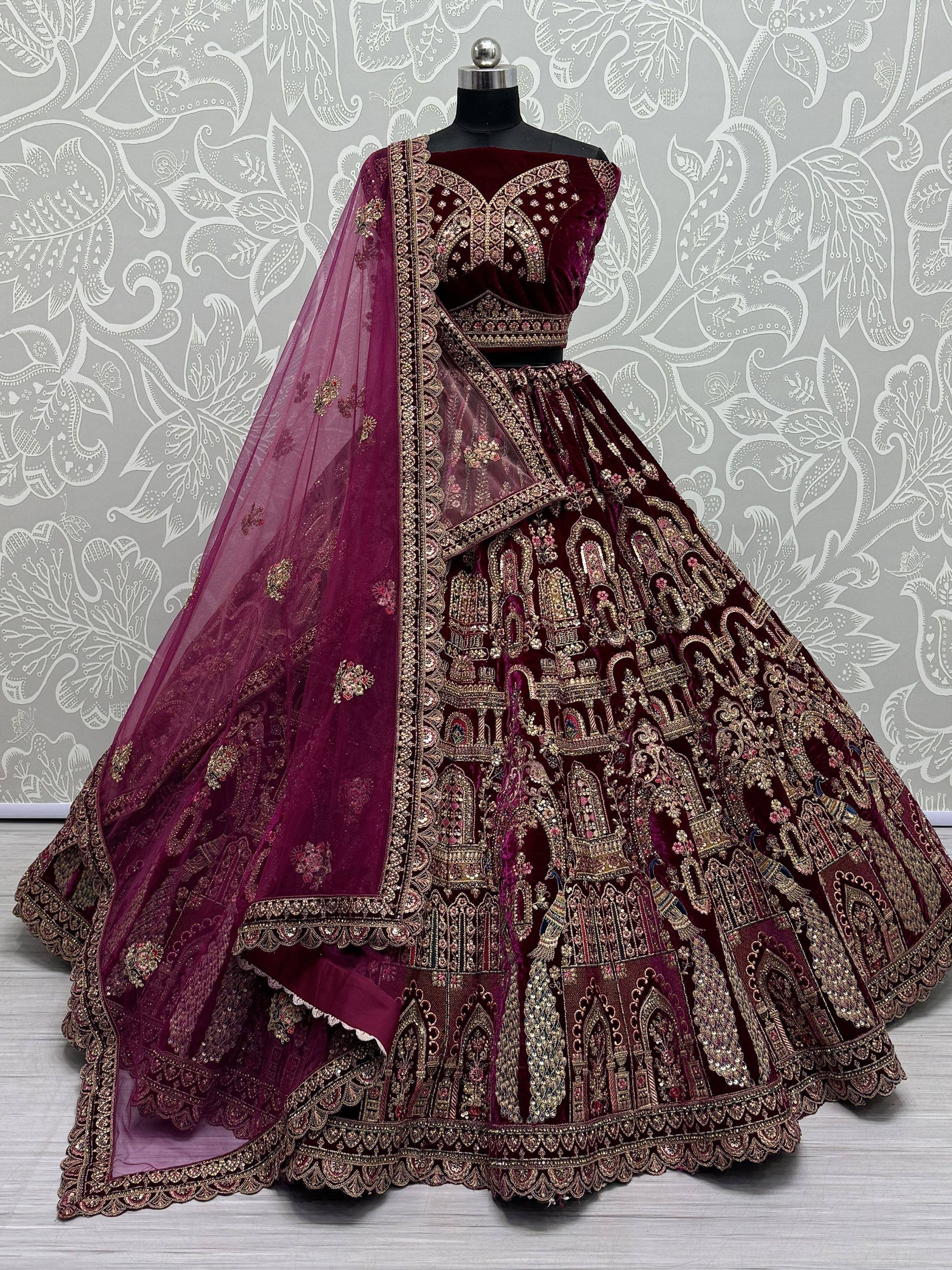 Burgundy velvet designer lehenga choli with heavy gold embroidery and matching dupatta, perfect for weddings.