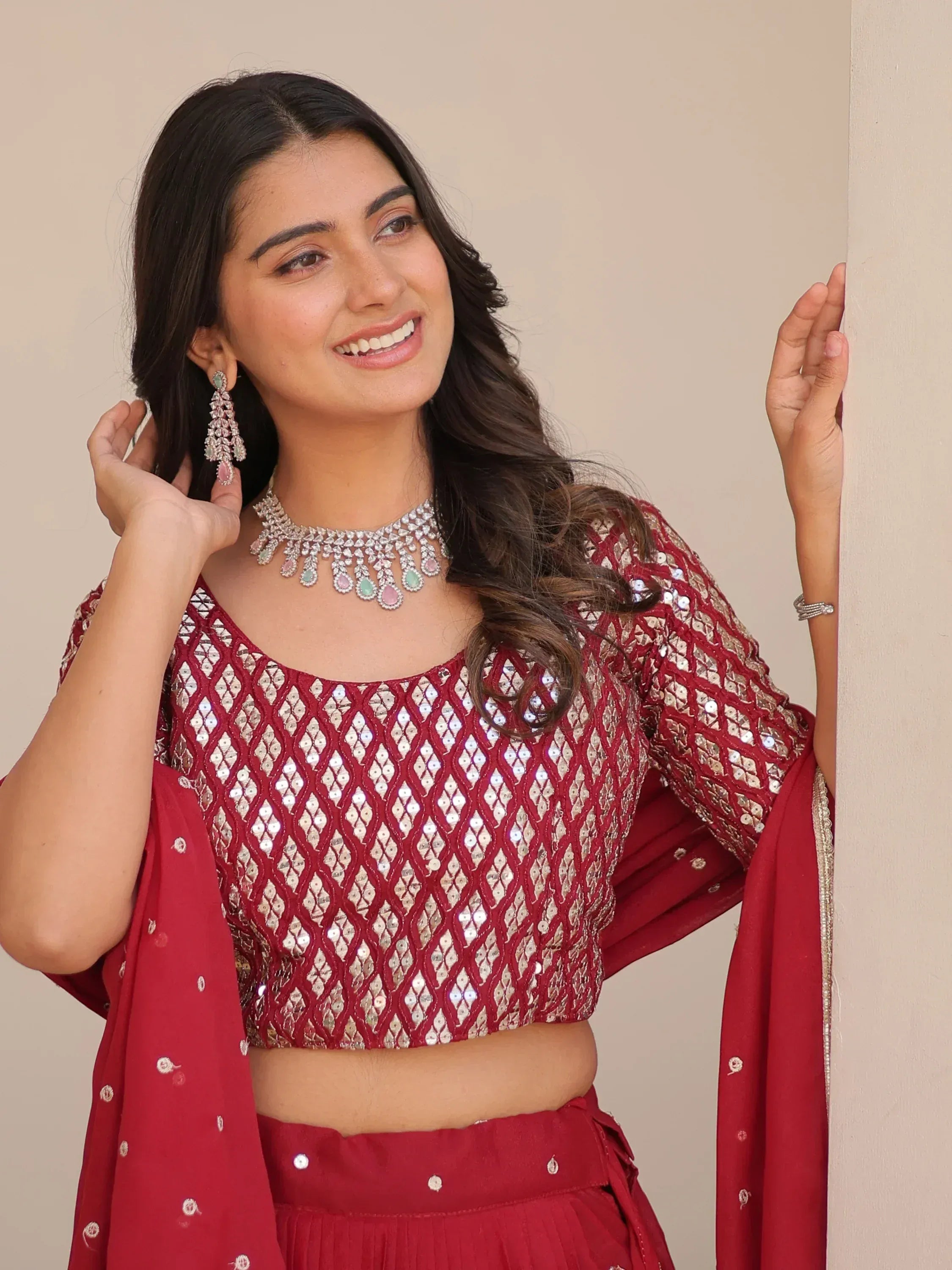 Woman in red sequin lehenga choli with matching dupatta and jewelry, perfect for Indian ethnic wear occasions.