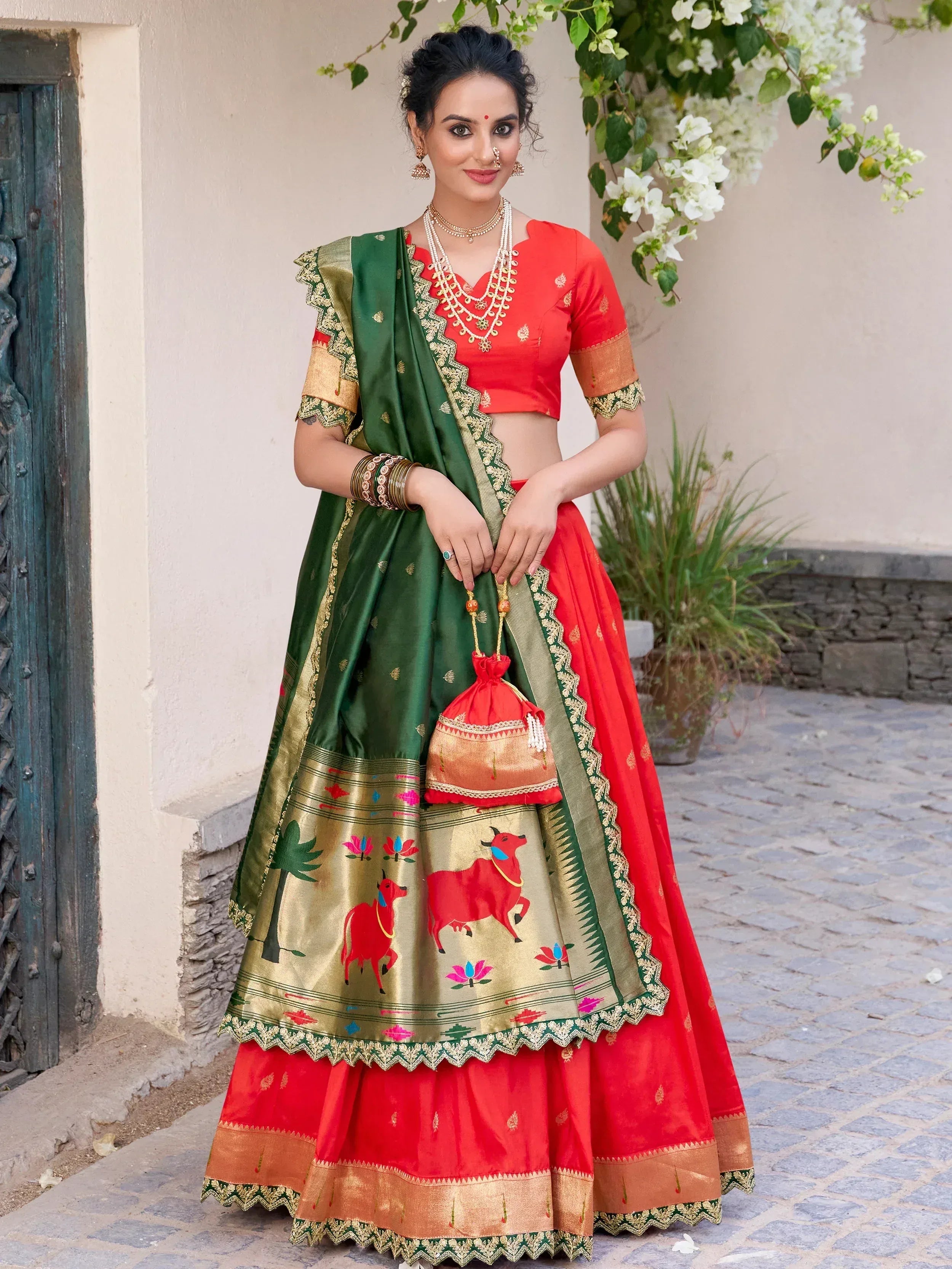 Red and green designer lehenga choli with bull motifs, perfect for Indian ethnic wear and festive occasions.
