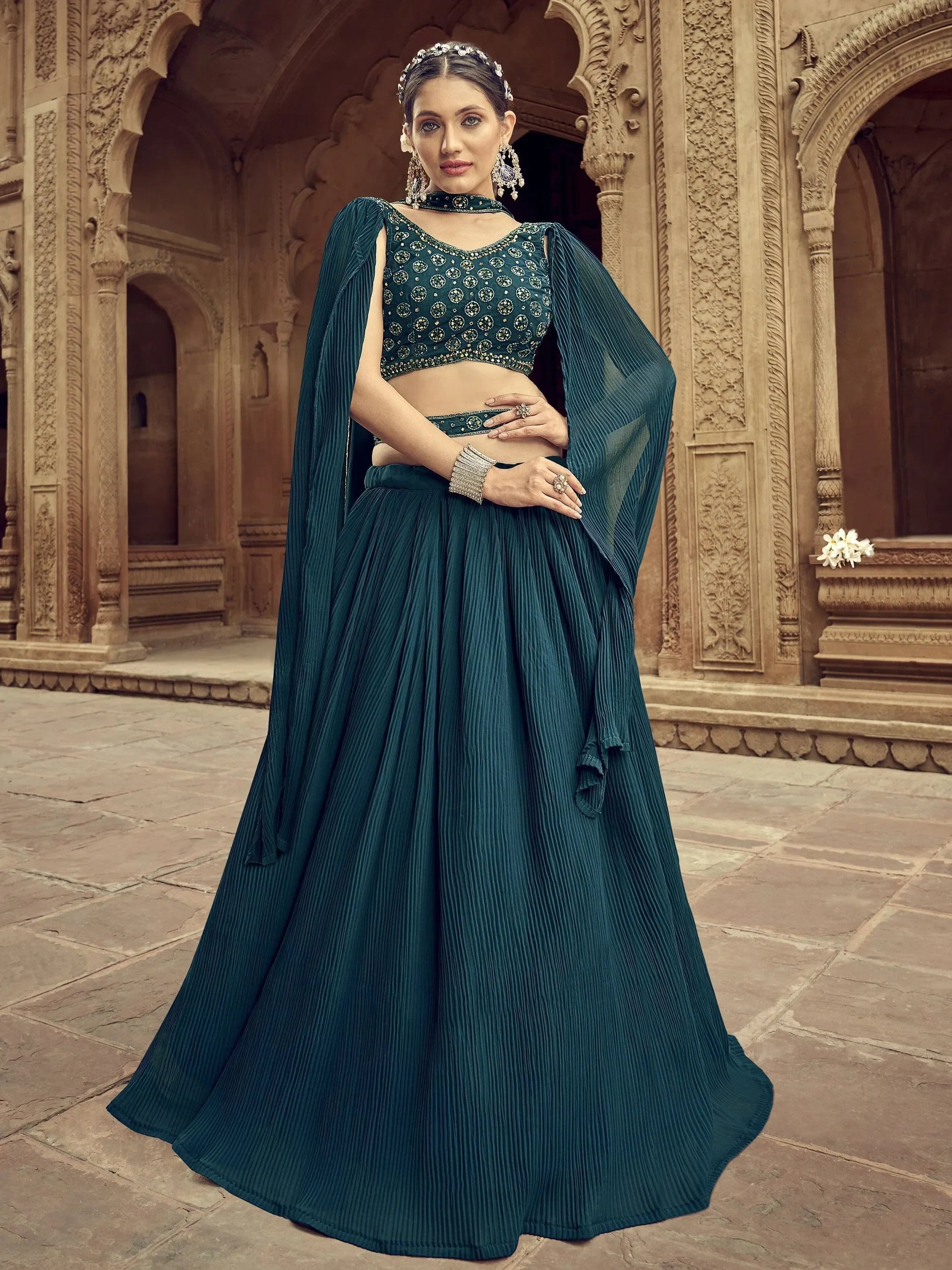 Teal designer lehenga choli with pleated skirt and cape, perfect for Indian ethnic wear occasions.