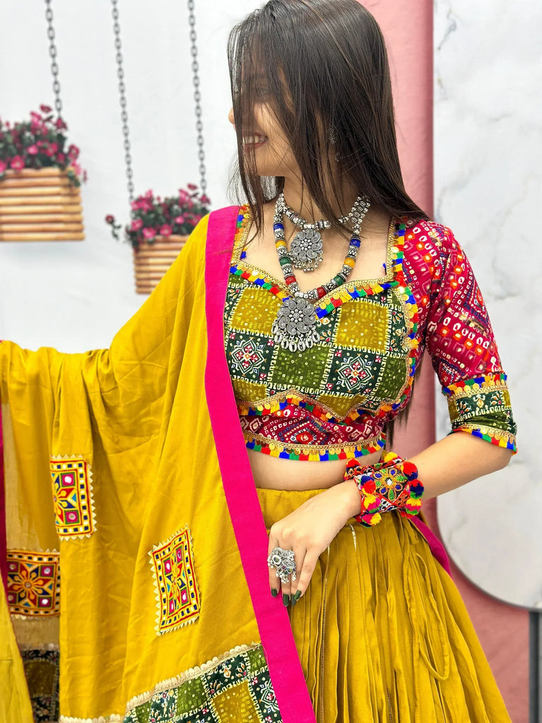 Vibrant yellow and pink Indian ethnic lehenga choli with mirror work, perfect for festive occasions.