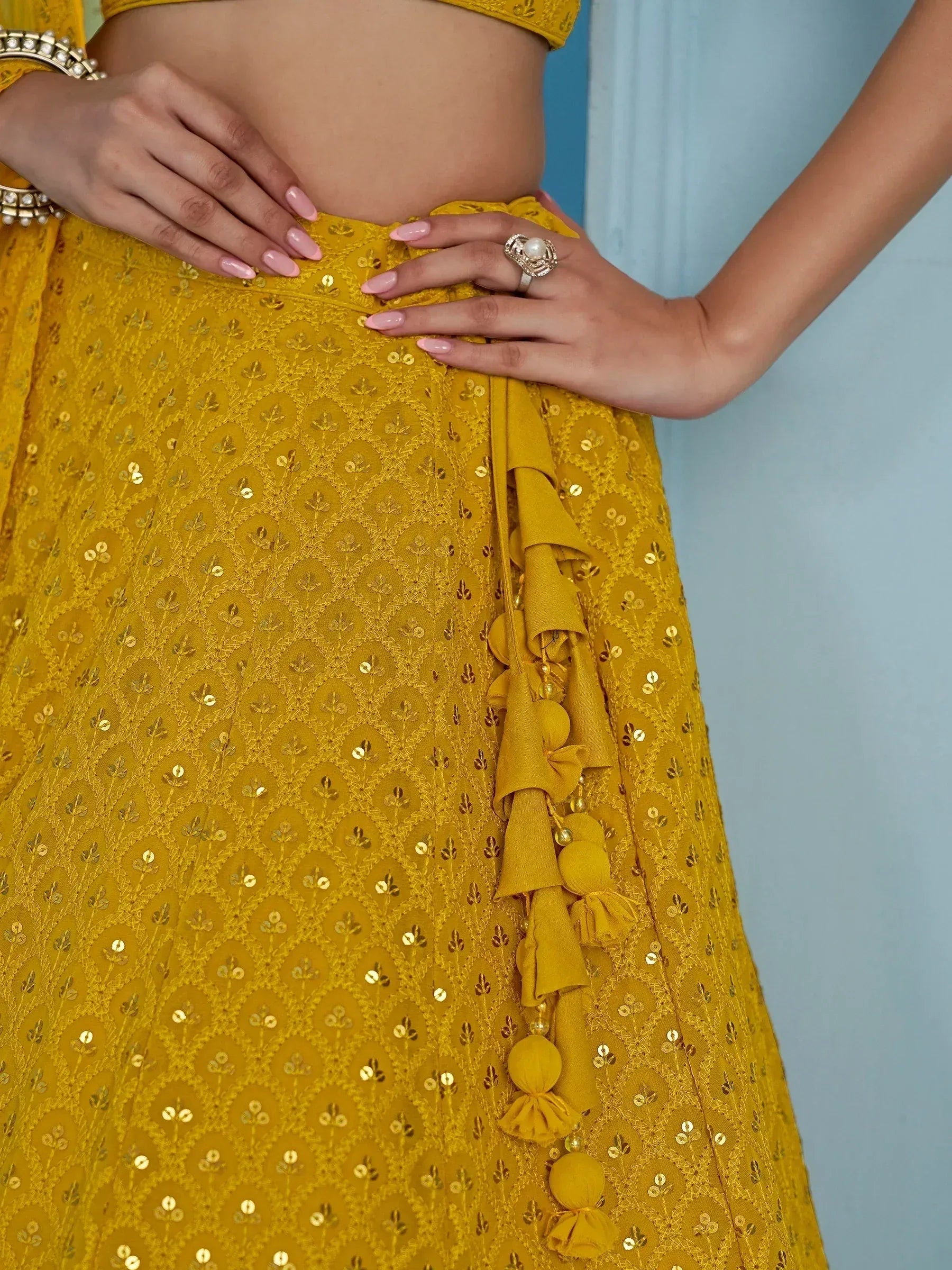 Yellow designer lehenga with gold sequin embroidery and tassel details, perfect for Indian ethnic wear