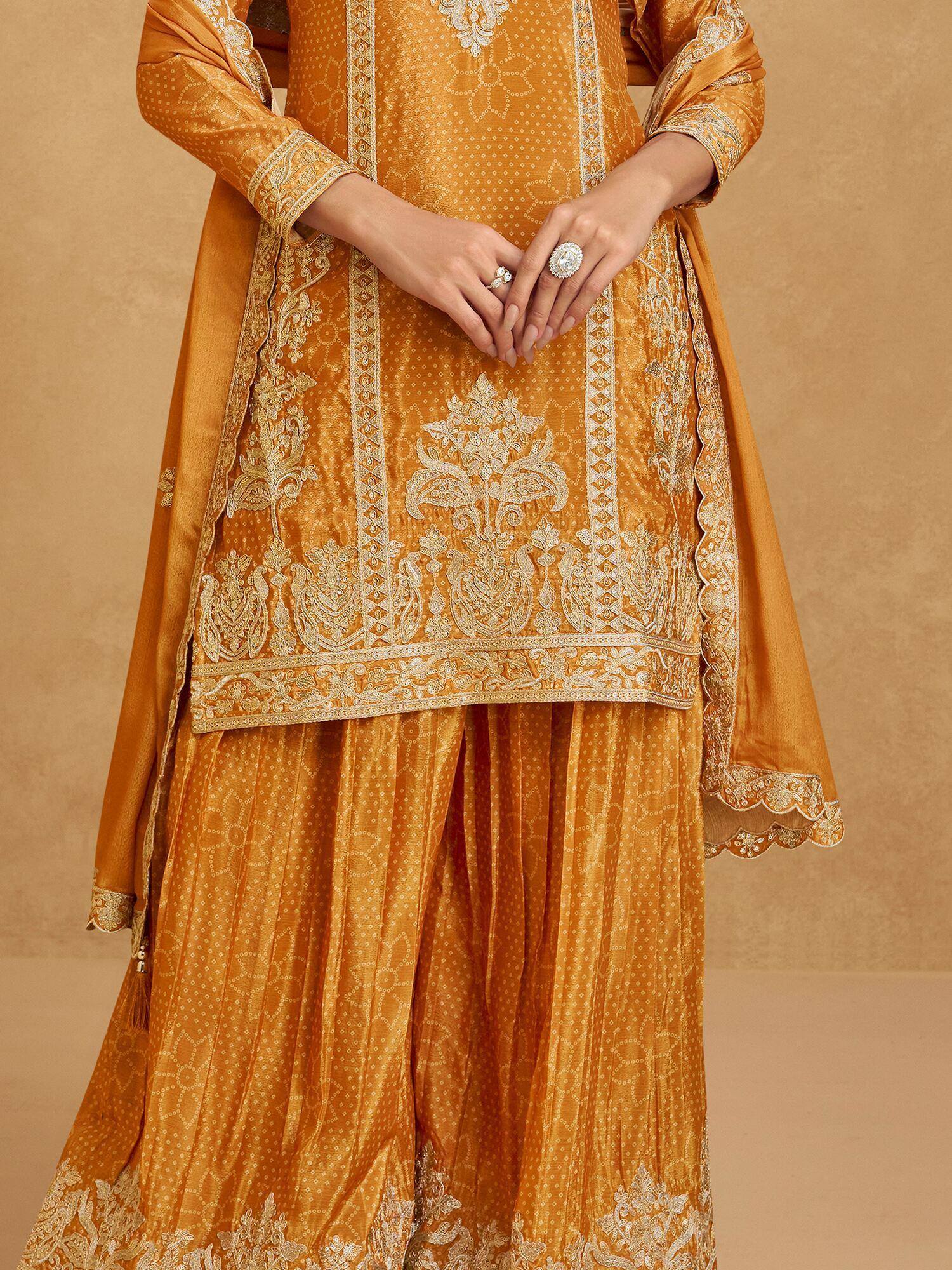 Mustard yellow embroidered salwar kameez with intricate white floral motifs and scalloped dupatta, perfect for ethnic occasions.
