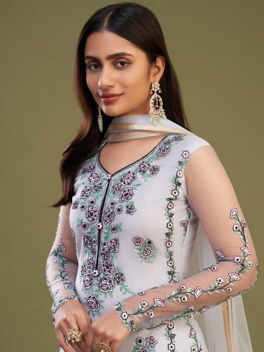 Woman in pastel embroidered salwar kameez with sheer floral sleeves and dupatta