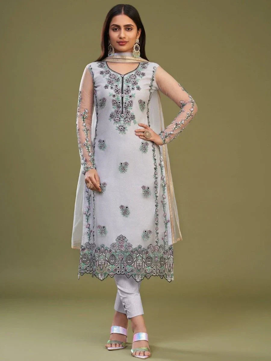 Woman wearing a light grey embroidered salwar kameez with sheer sleeves and churidar pants