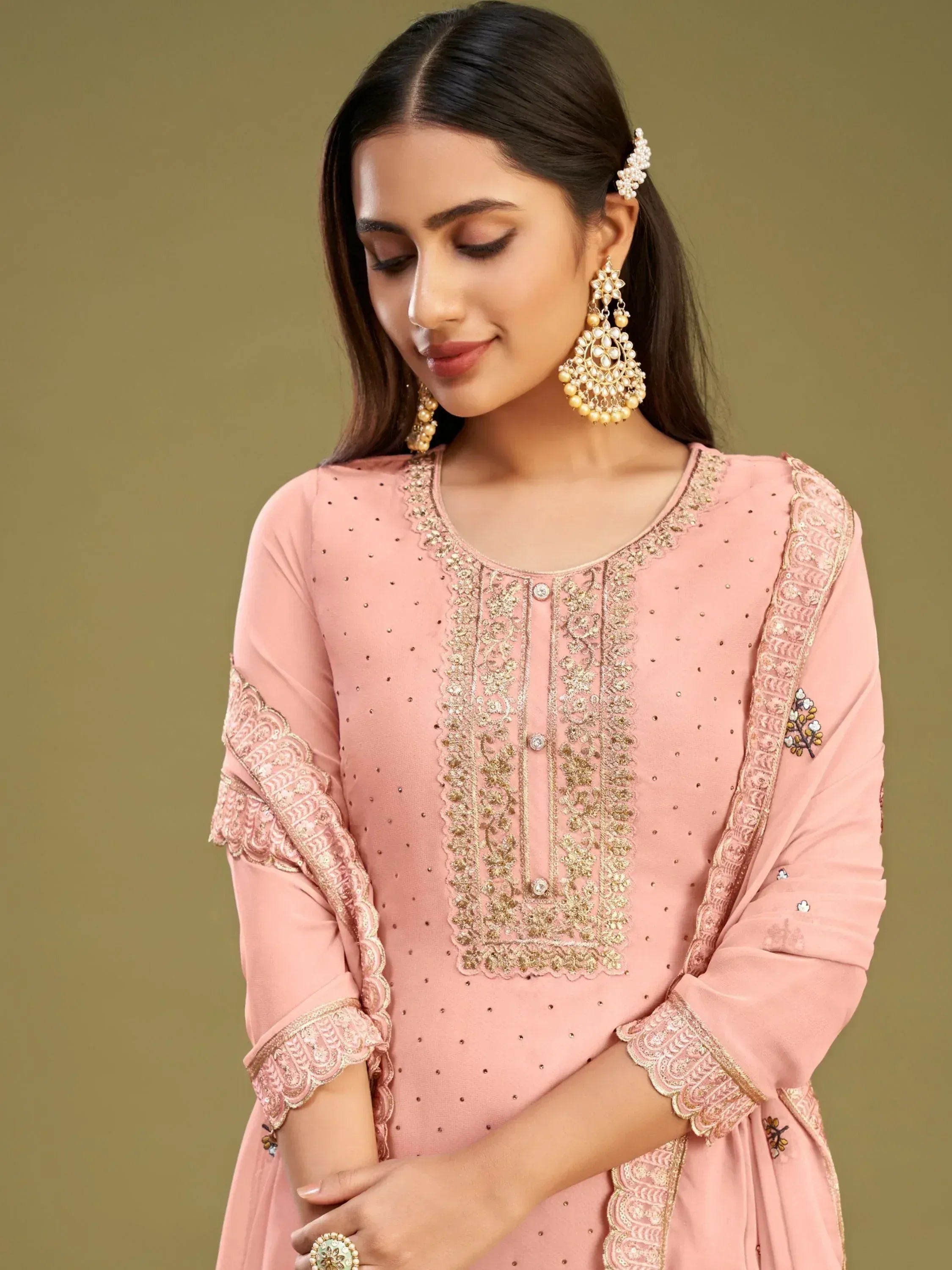 Pink embroidered ethnic kurti with gold detailing and matching jewelry