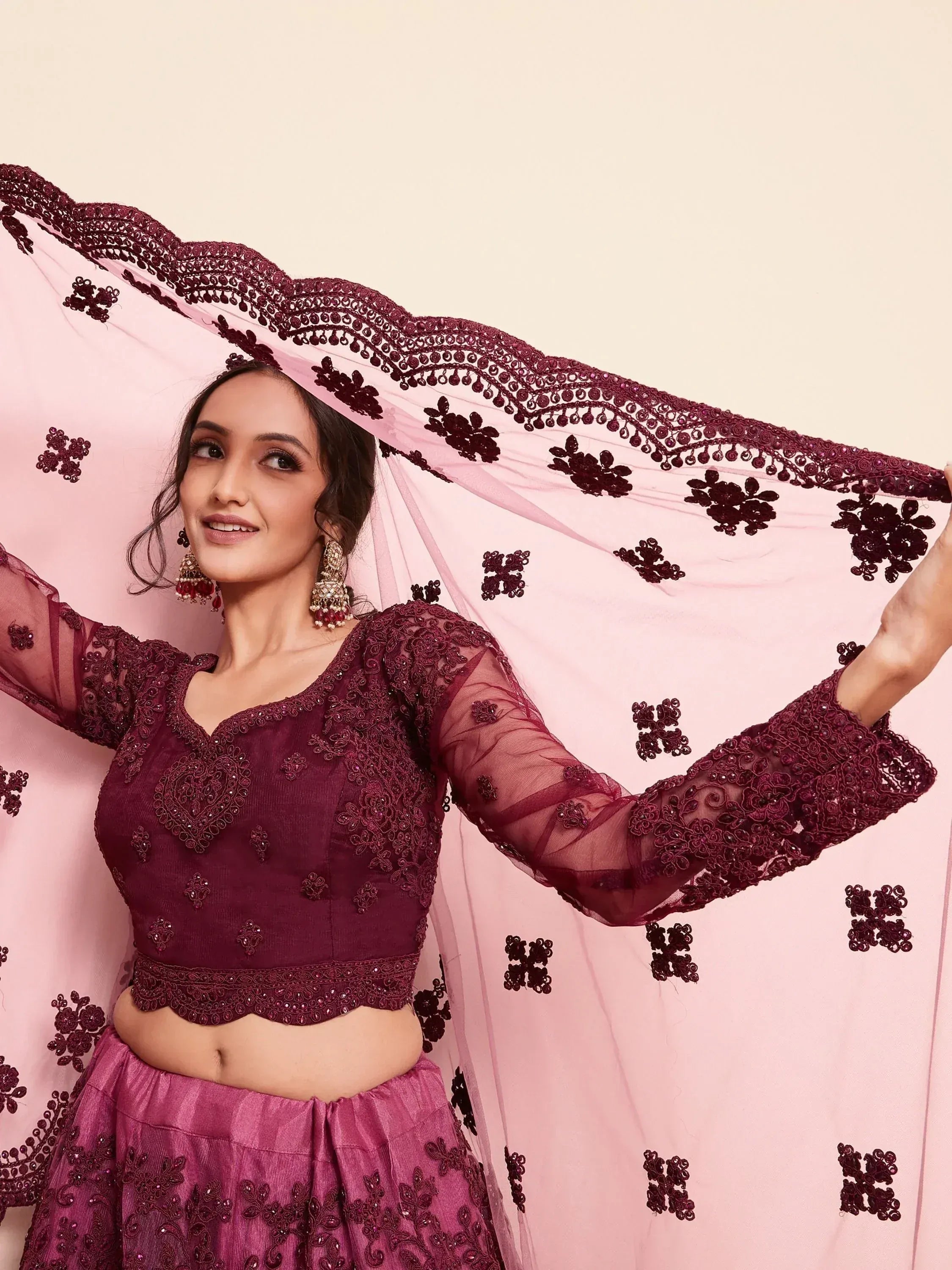 Elegant maroon lehenga choli with intricate embroidery and sheer dupatta, perfect for Indian ethnic occasions.