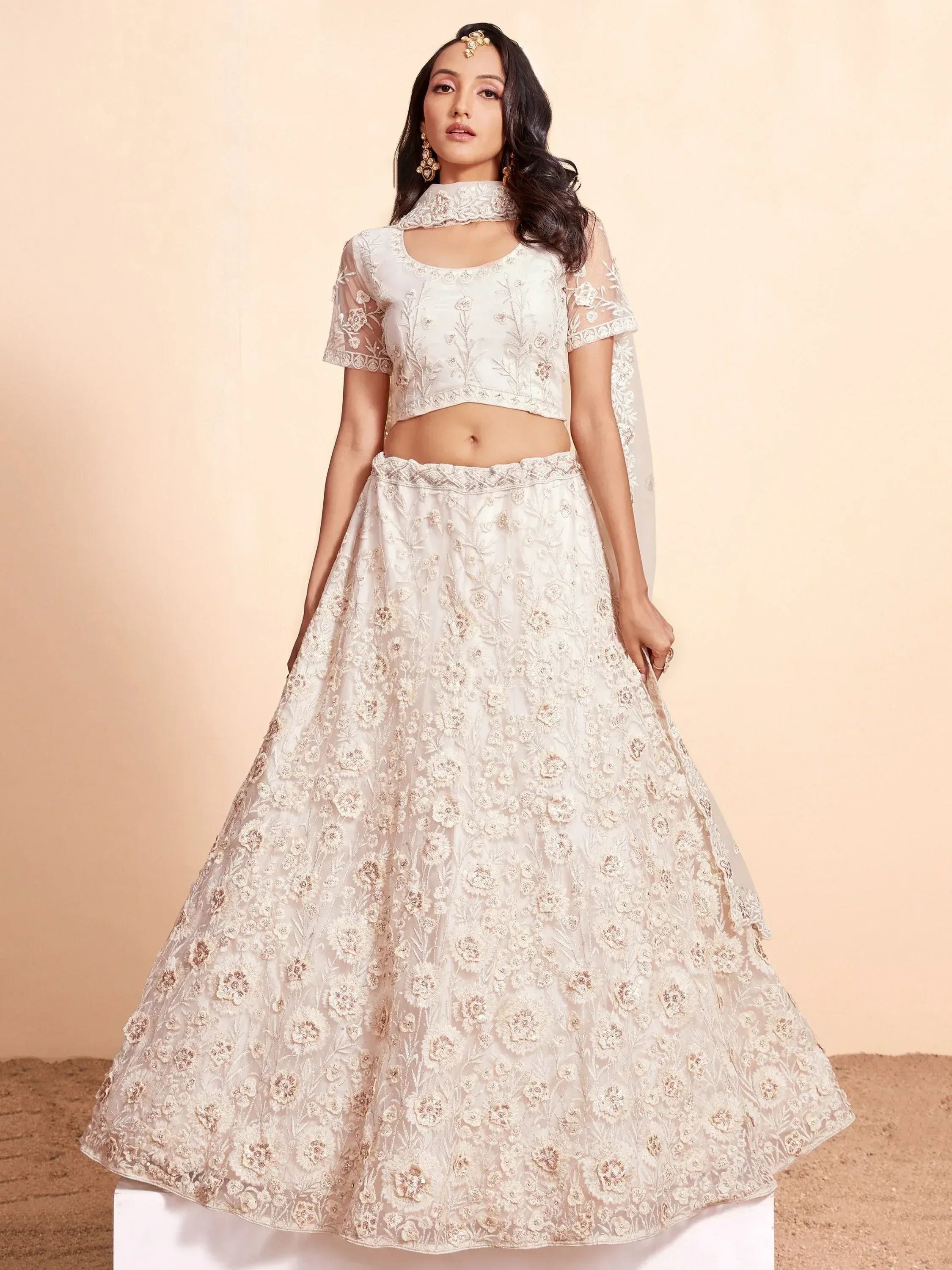 Elegant white floral embroidered lehenga choli with sheer sleeves and dupatta, perfect for Indian weddings or festive occasions.