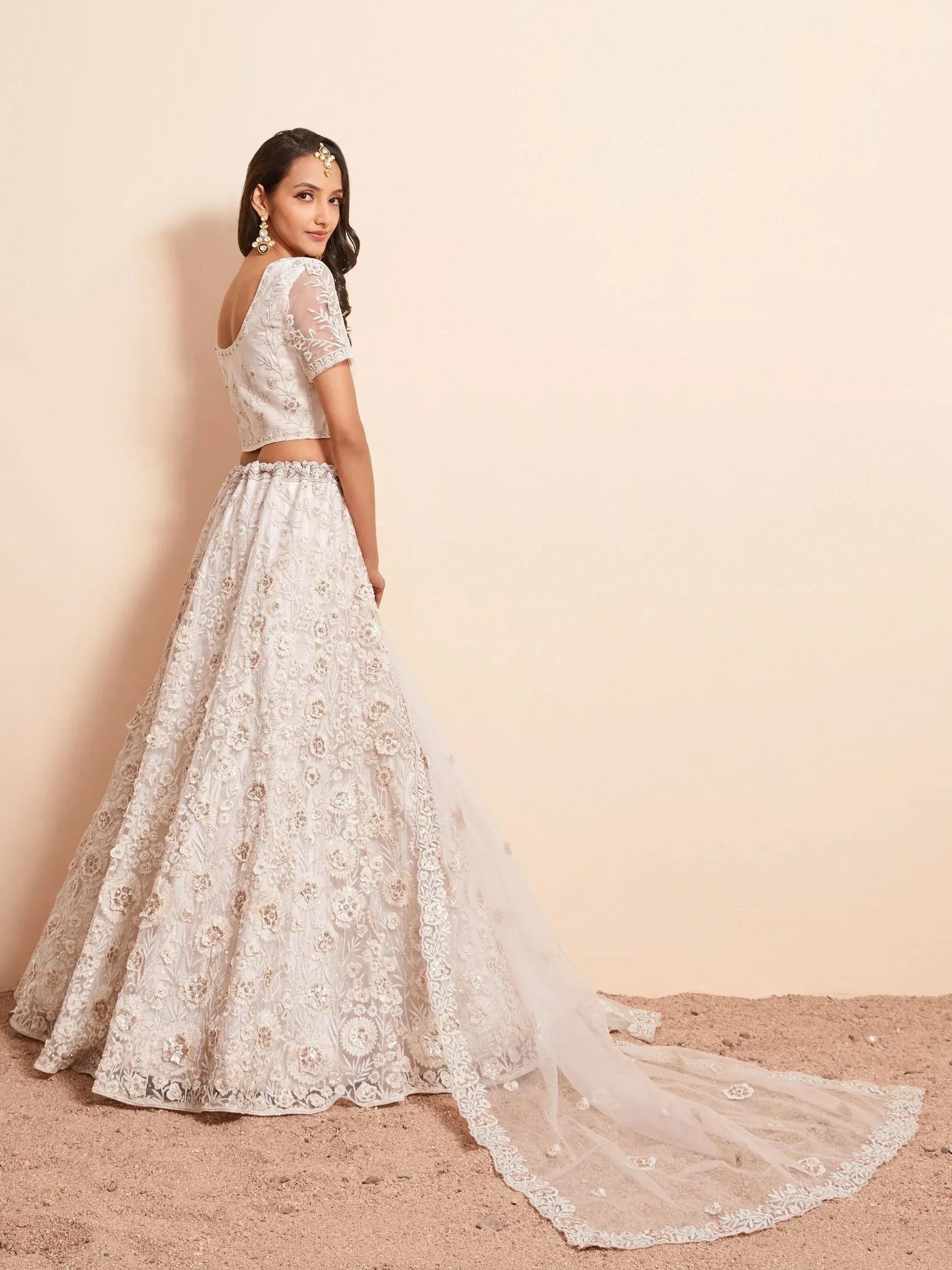 Elegant white embroidered lehenga choli with floral detailing and sheer dupatta, perfect for Indian weddings.