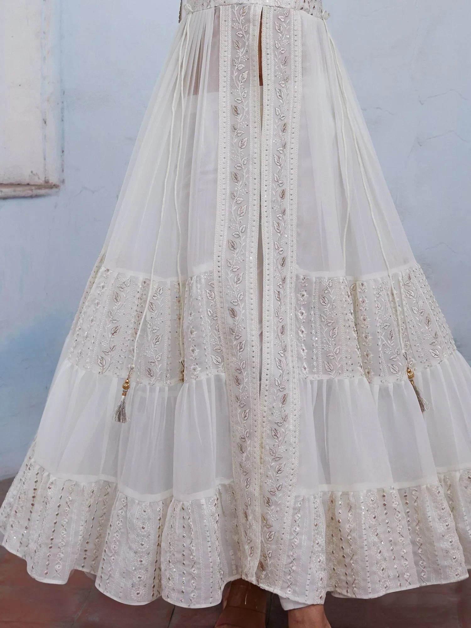 Ivory embroidered ethnic gown with sheer panels and gold tassel accents