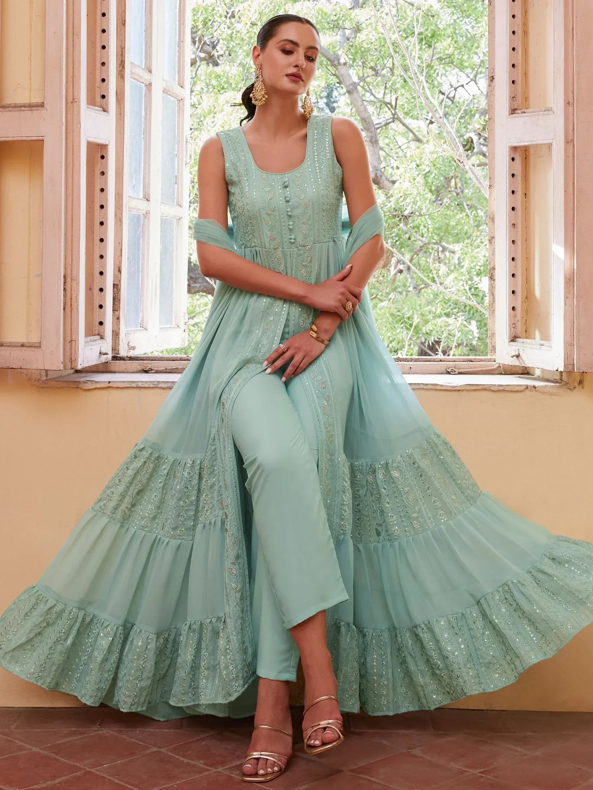 Mint green embroidered ethnic gown with tiered skirt and matching pants, perfect for Indian occasions.