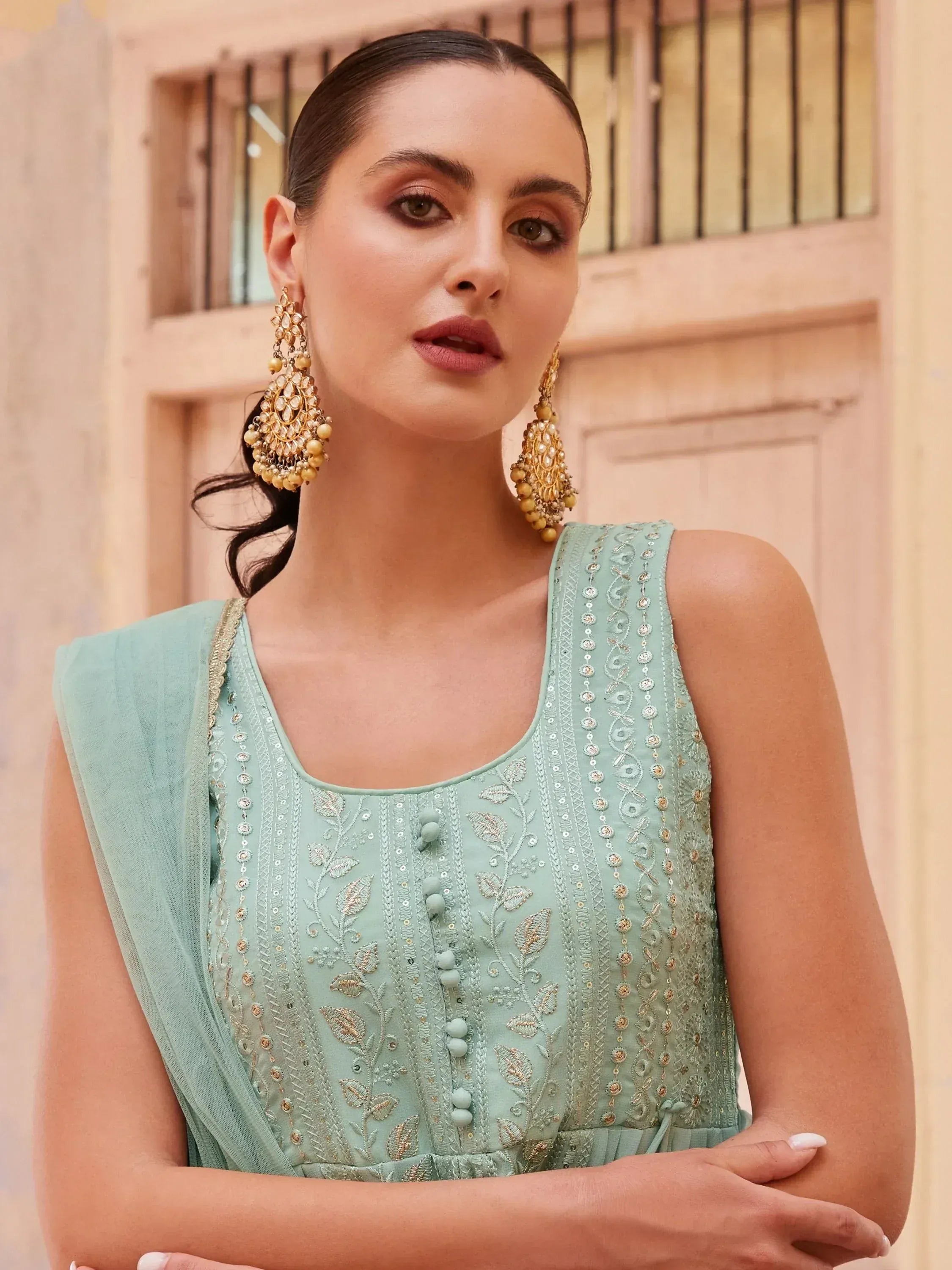 Mint green embroidered ethnic gown with gold detailing and statement earrings