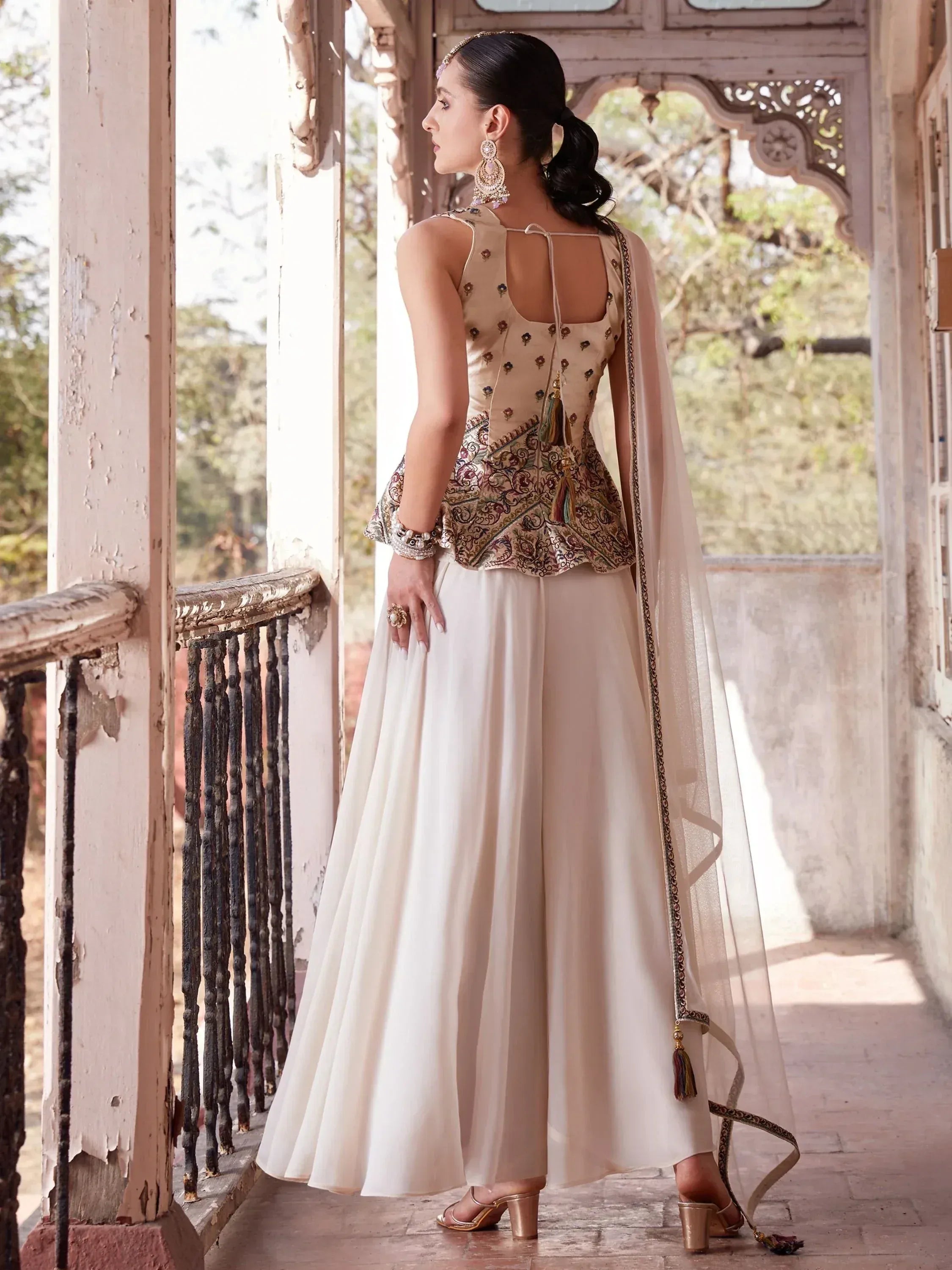 Woman in cream embroidered lehenga choli with dupatta, traditional Indian ethnic wear