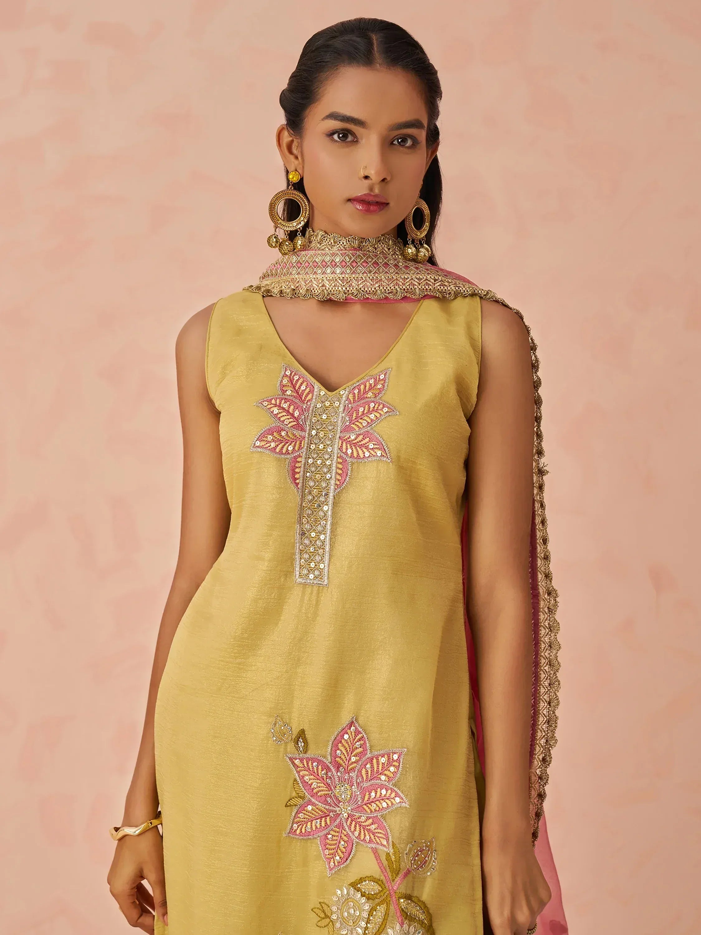 Yellow sleeveless kurta with pink floral embroidery and matching dupatta, styled with gold jewelry for ethnic wear.
