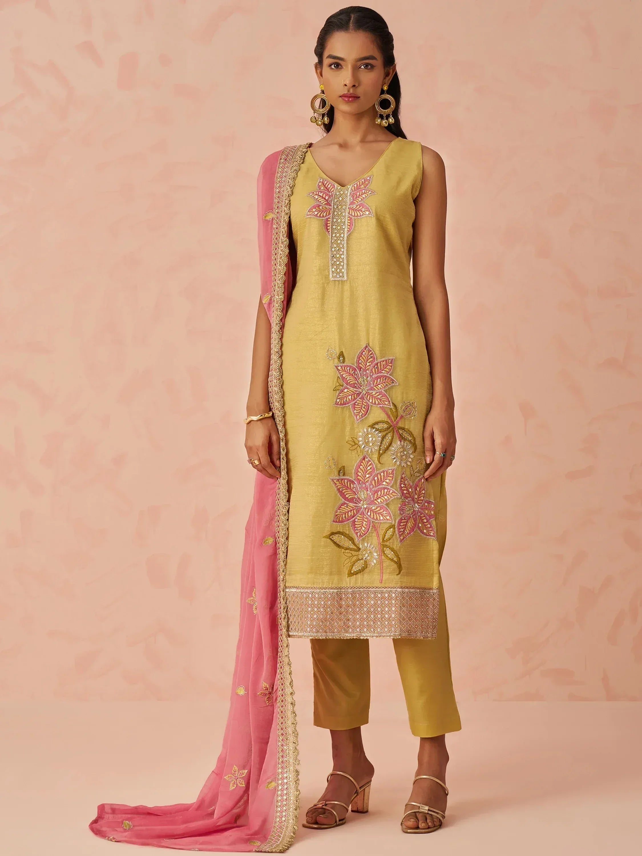 Yellow embroidered kurta with pink dupatta, floral embellishments, and matching pants for ethnic wear