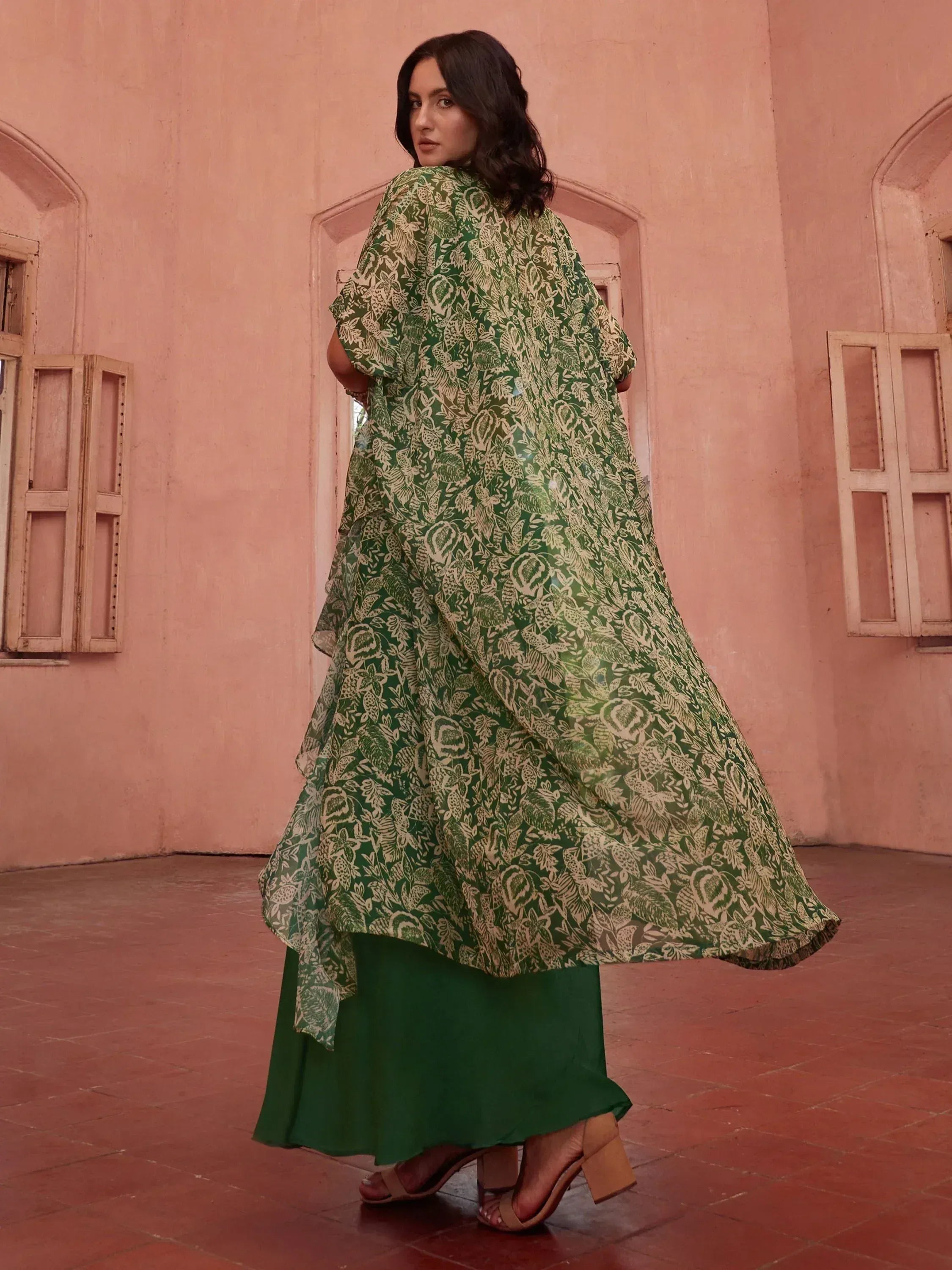 Green floral print ethnic gown with layered hem, styled for Indian occasions
