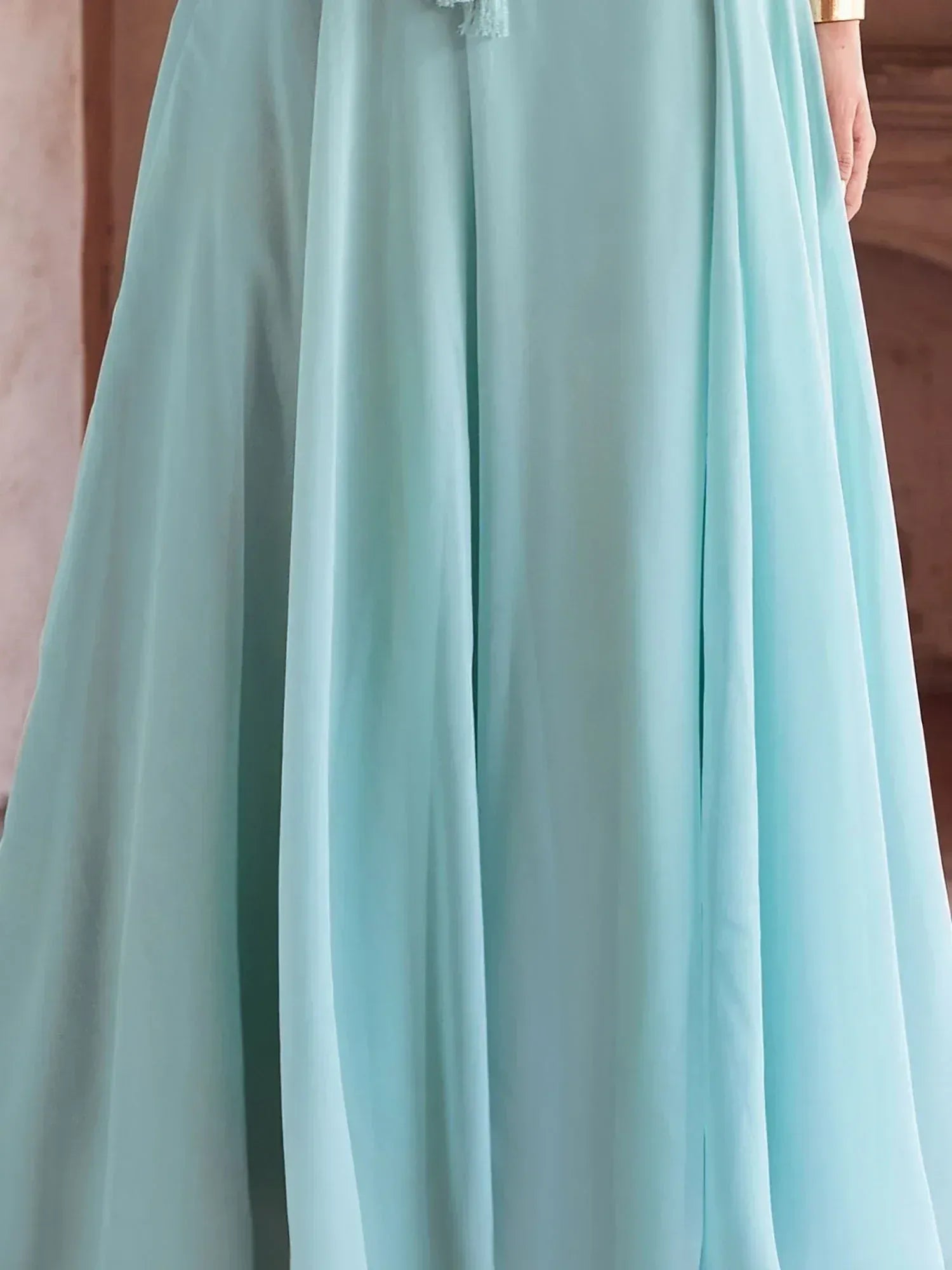 Mint green ethnic gown with flowing skirt and gold cuff, perfect for Indian festive wear