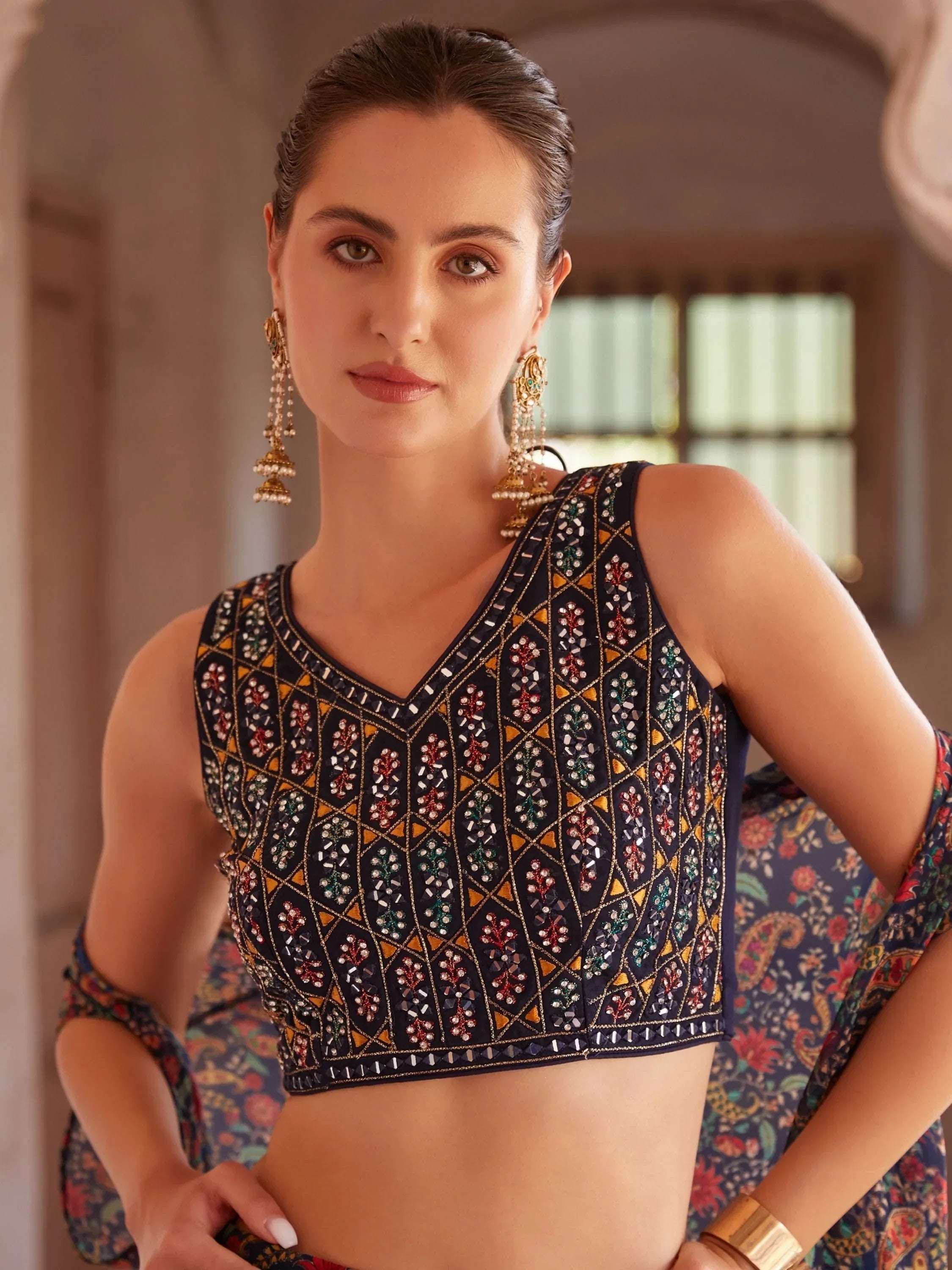 Woman wearing a navy blue embroidered ethnic blouse and dupatta, dangling earrings