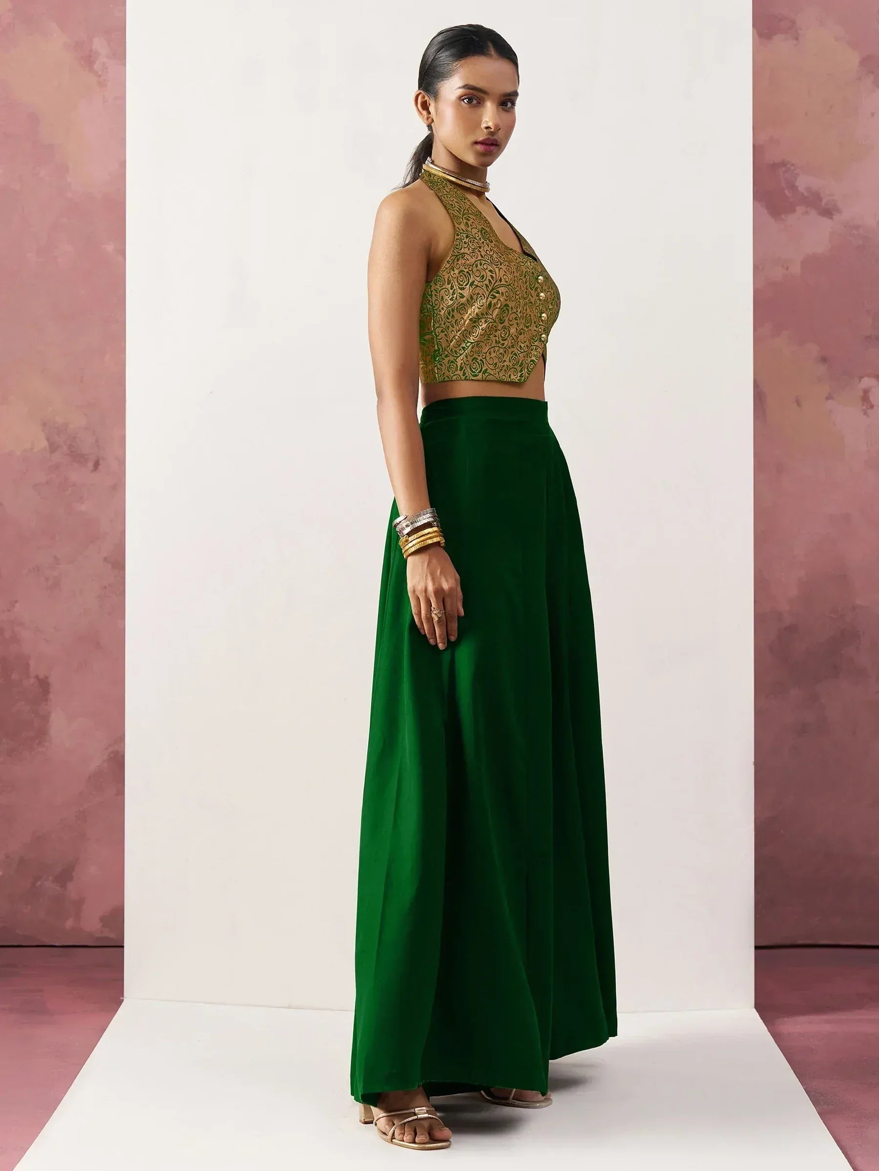 Emerald green ethnic skirt with gold embroidered crop top, perfect for Indian festive occasions.