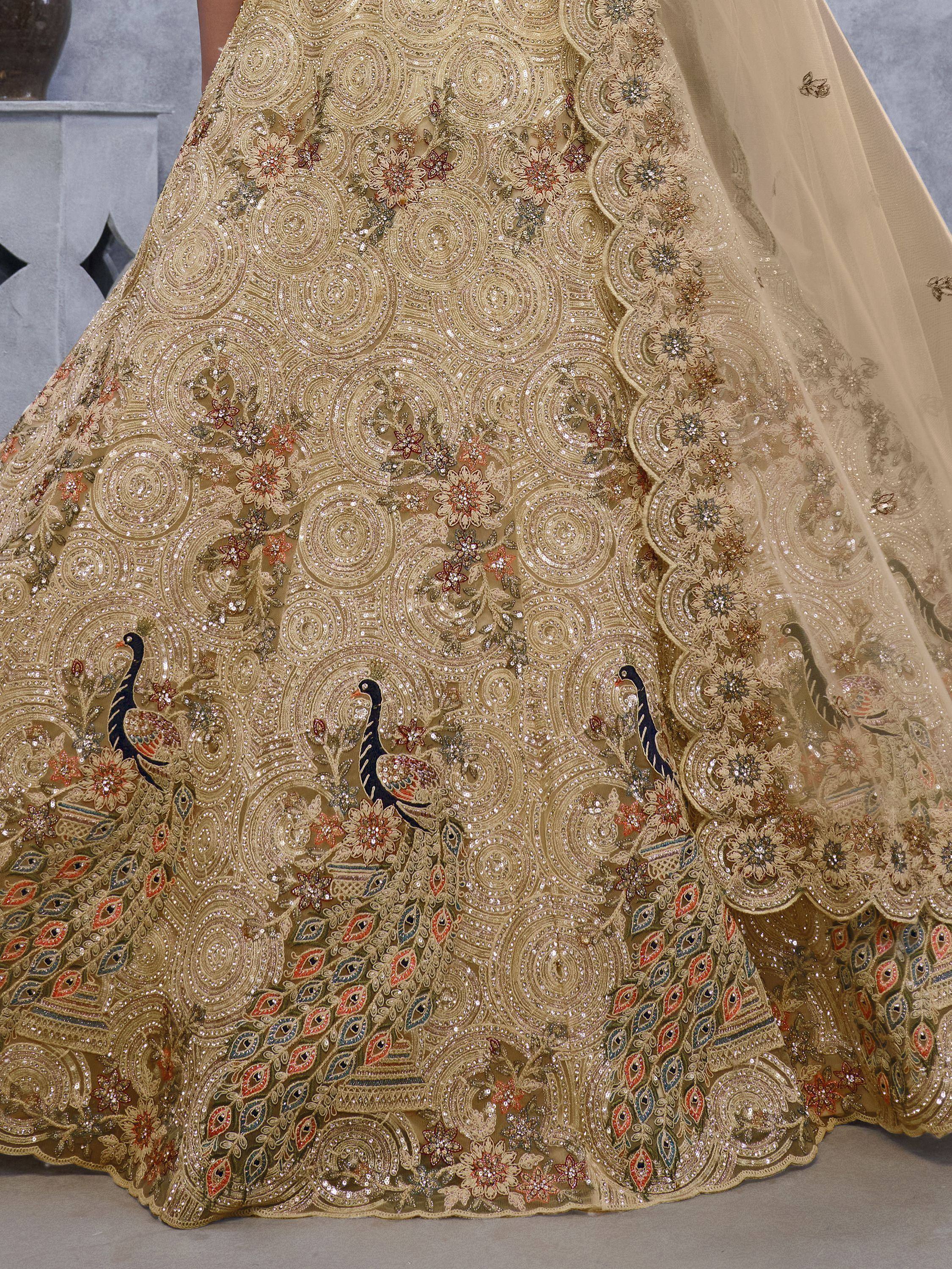 Gold designer lehenga with peacock embroidery and floral motifs, perfect for Indian weddings and festive occasions.