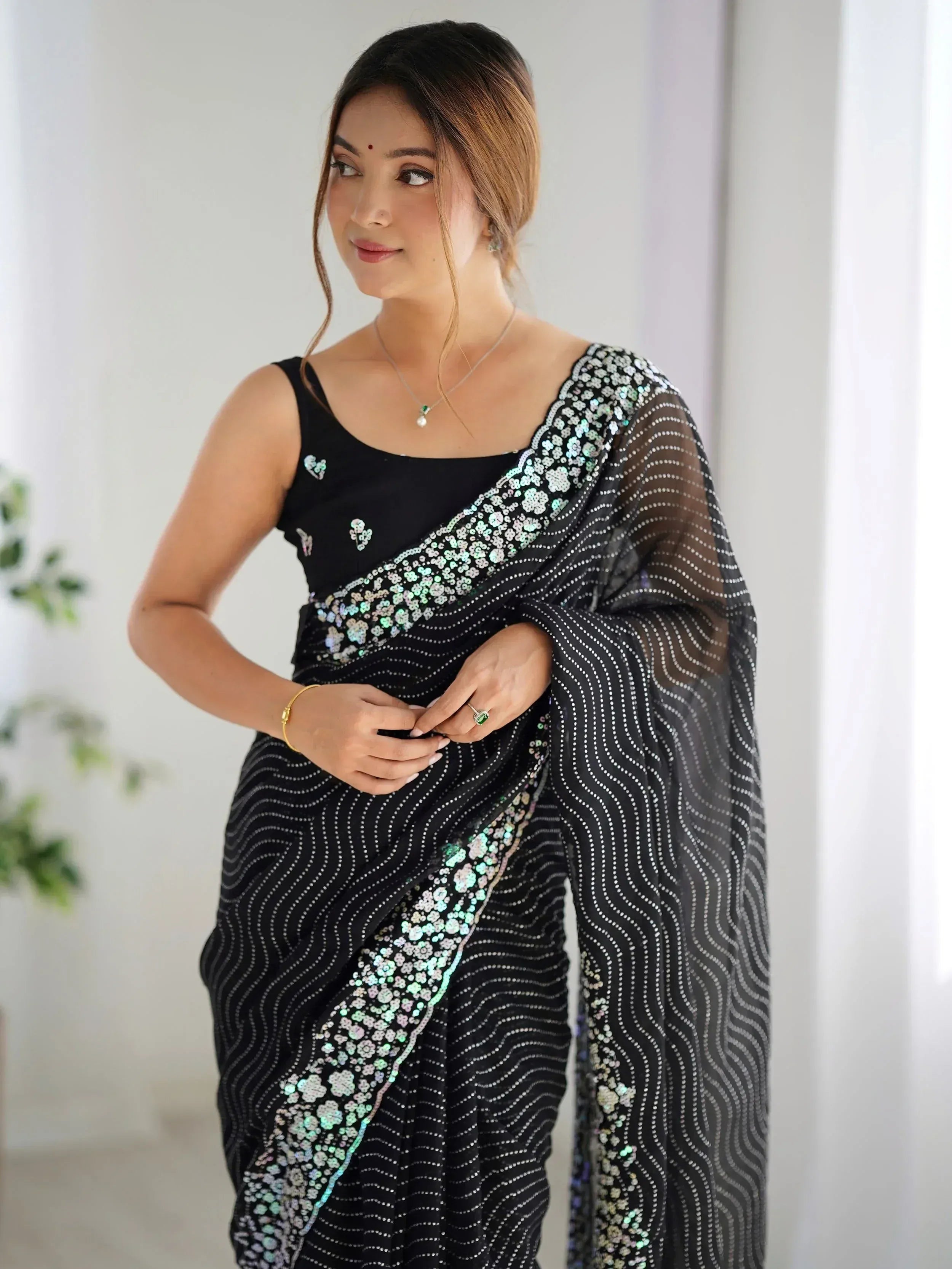 Black sequin saree with floral border, perfect for Indian ethnic wear and festive occasions