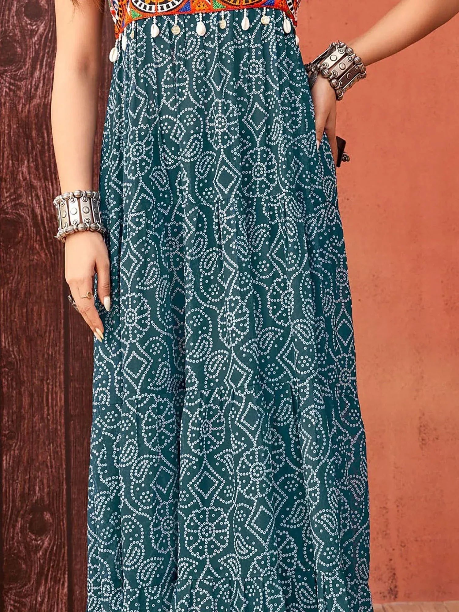 Teal ethnic gown with white dot print, embroidered top, and shell tassels, paired with silver bangles