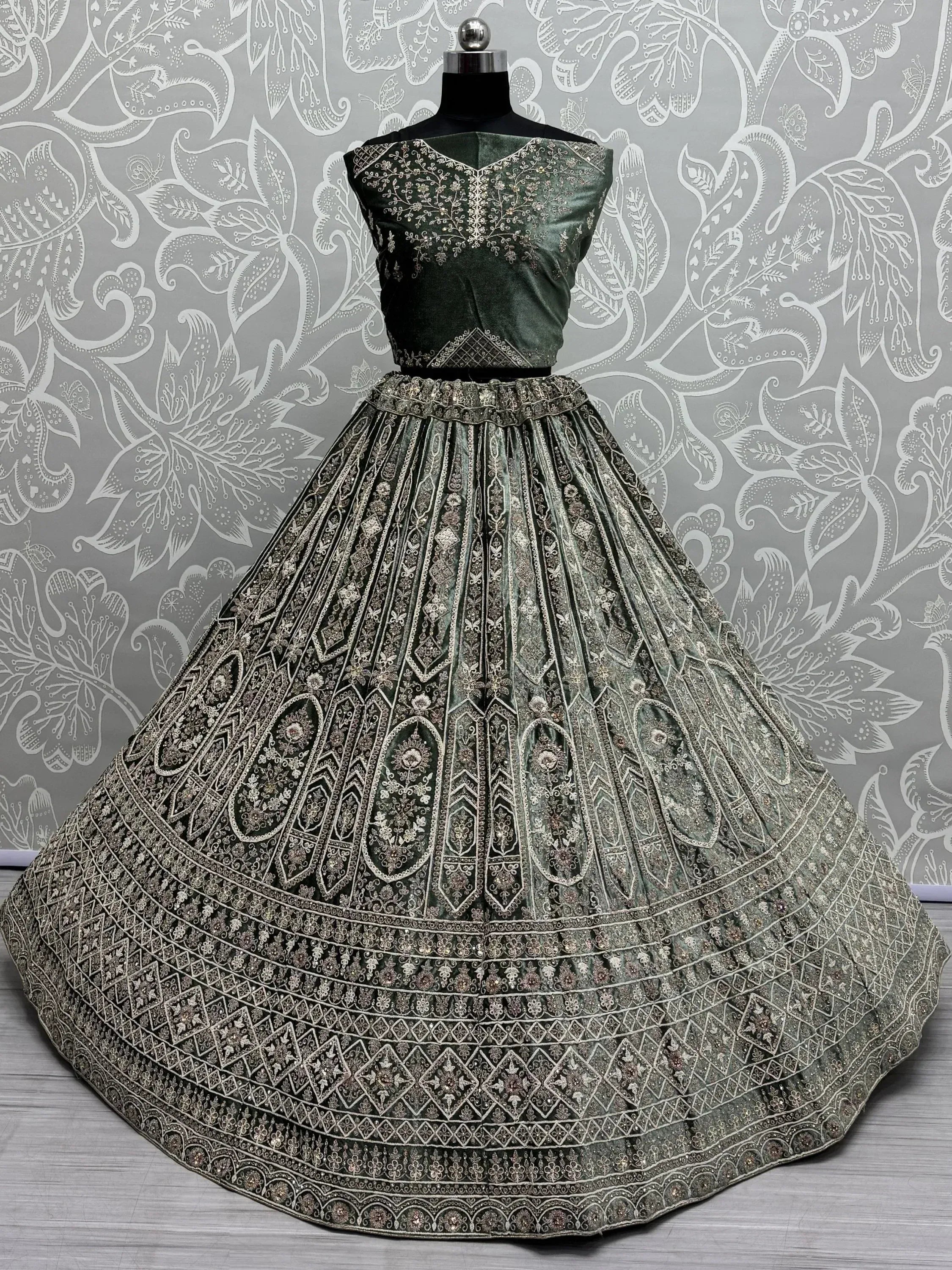 Emerald green velvet lehenga choli with intricate gold embroidery, perfect for Indian weddings and festive occasions.