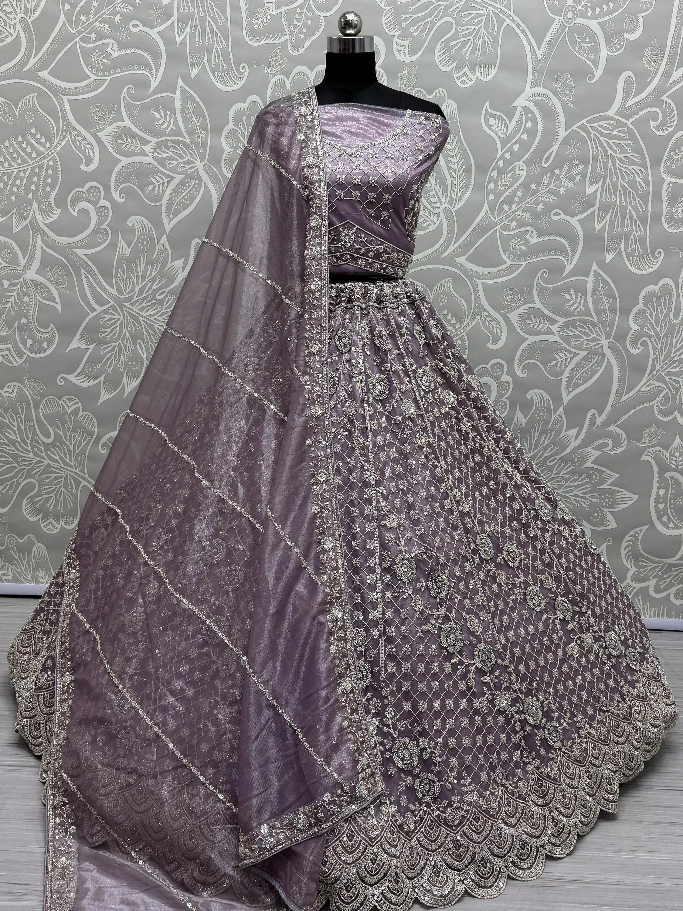 Elegant purple lehenga choli with intricate silver embroidery and net dupatta, perfect for Indian ethnic occasions.