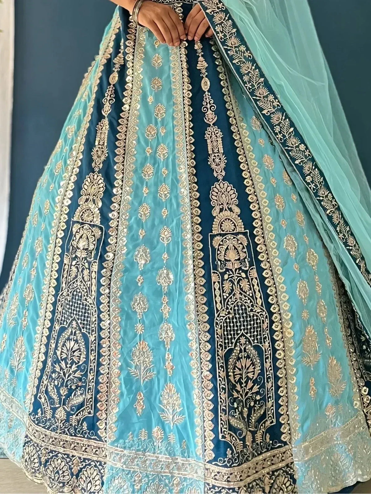 Blue and teal designer lehenga choli with gold embroidery and floral motifs, perfect for Indian weddings.