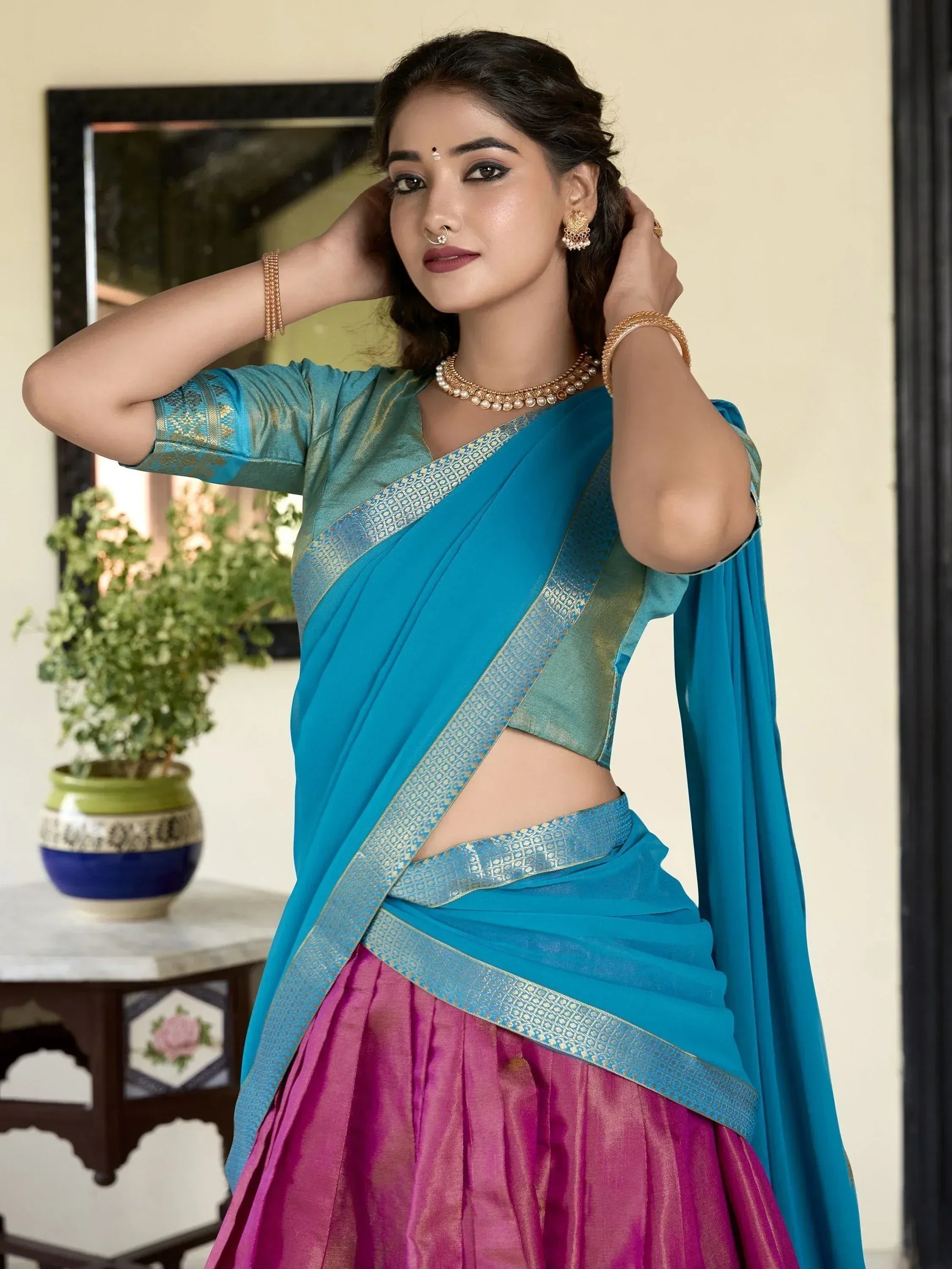 Woman in blue and pink designer saree with gold border, ethnic wear for festive occasions