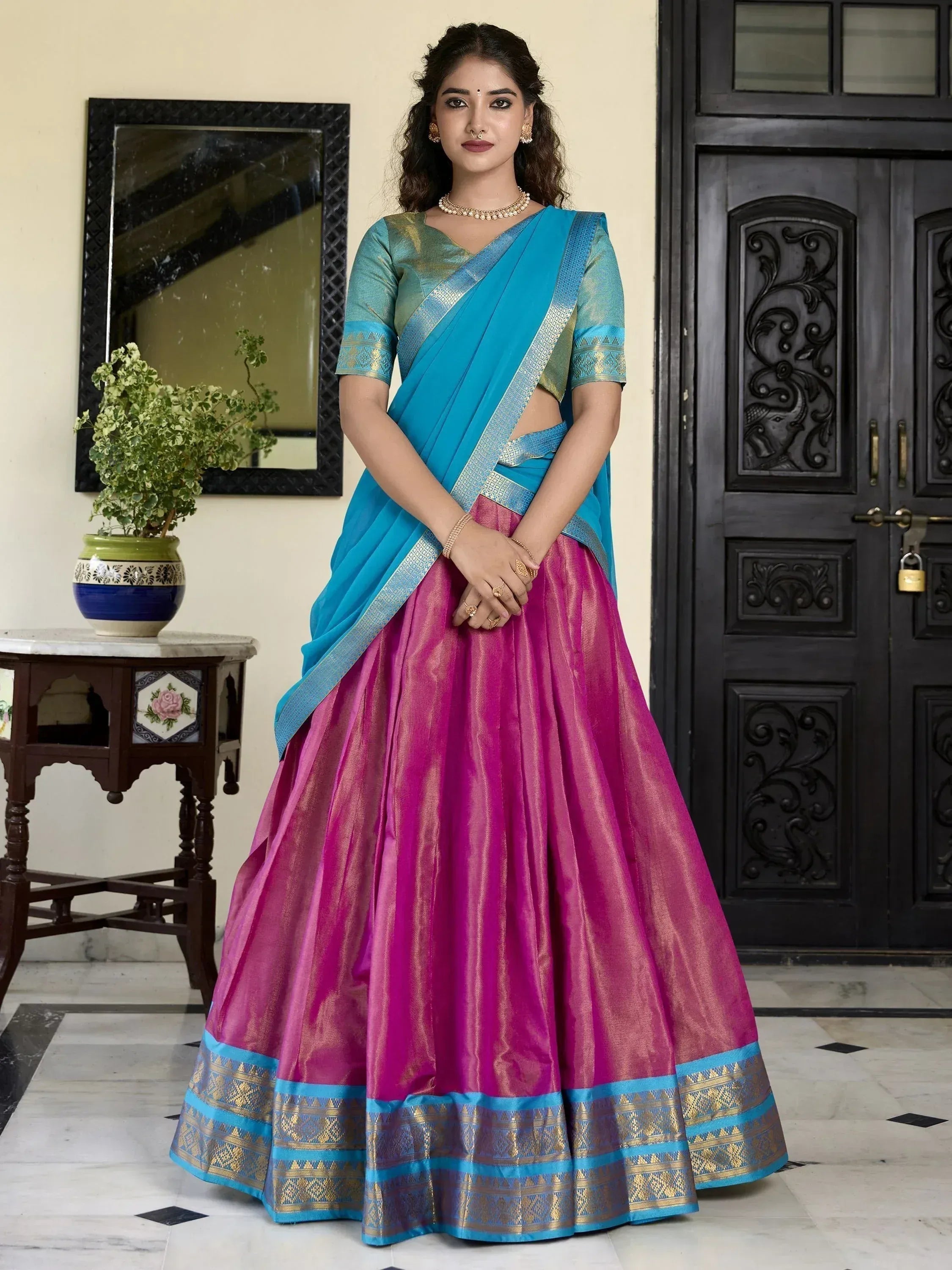 Vibrant pink and blue designer lehenga choli with gold border, perfect for Indian ethnic wear occasions