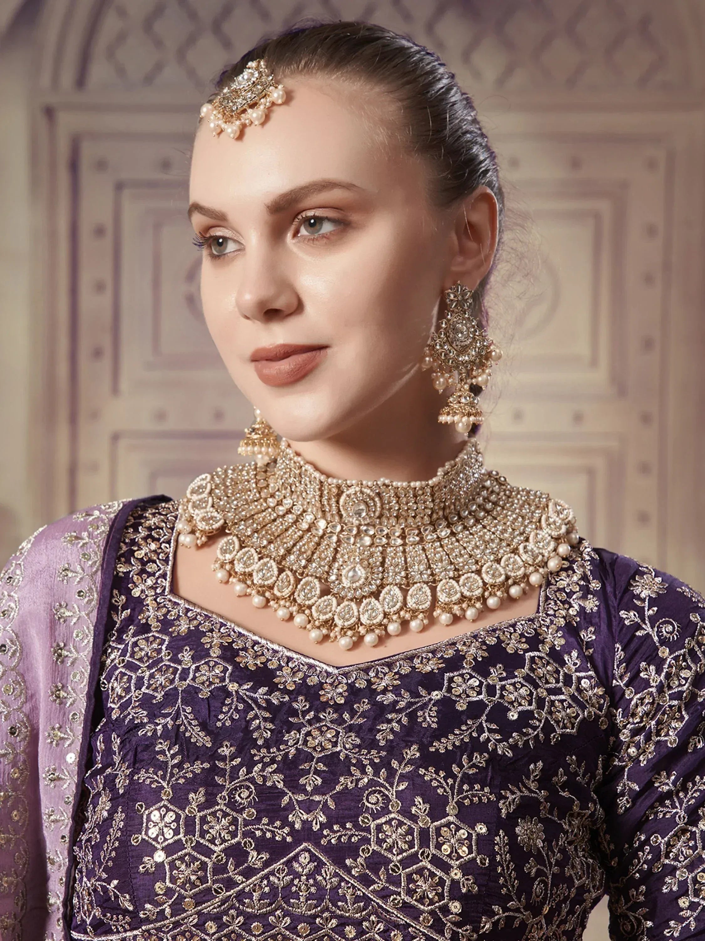 Elegant purple embroidered ethnic wear with pearl and gold jewelry set