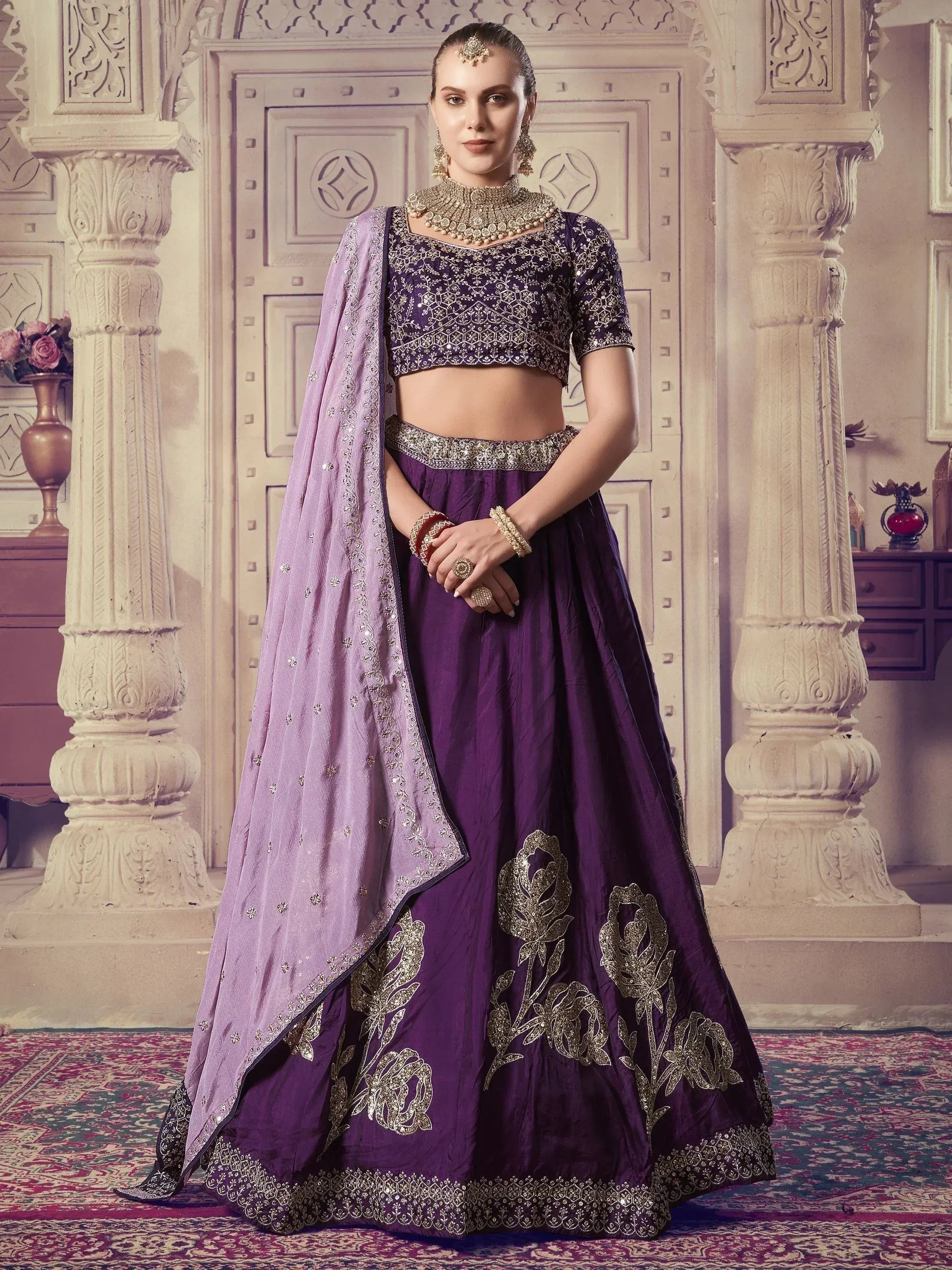 Purple designer lehenga choli with gold embroidery and matching dupatta, perfect for Indian weddings and festive occasions.