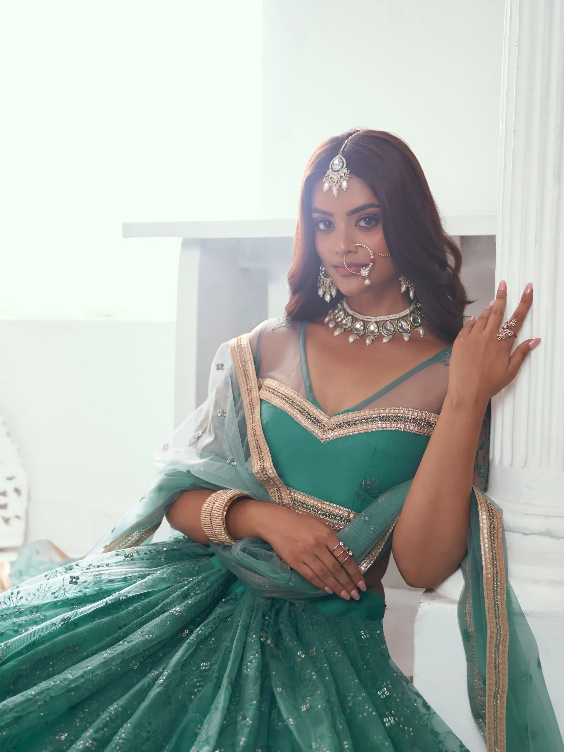 Emerald green designer lehenga choli with gold embroidery and traditional jewelry for Indian ethnic wear