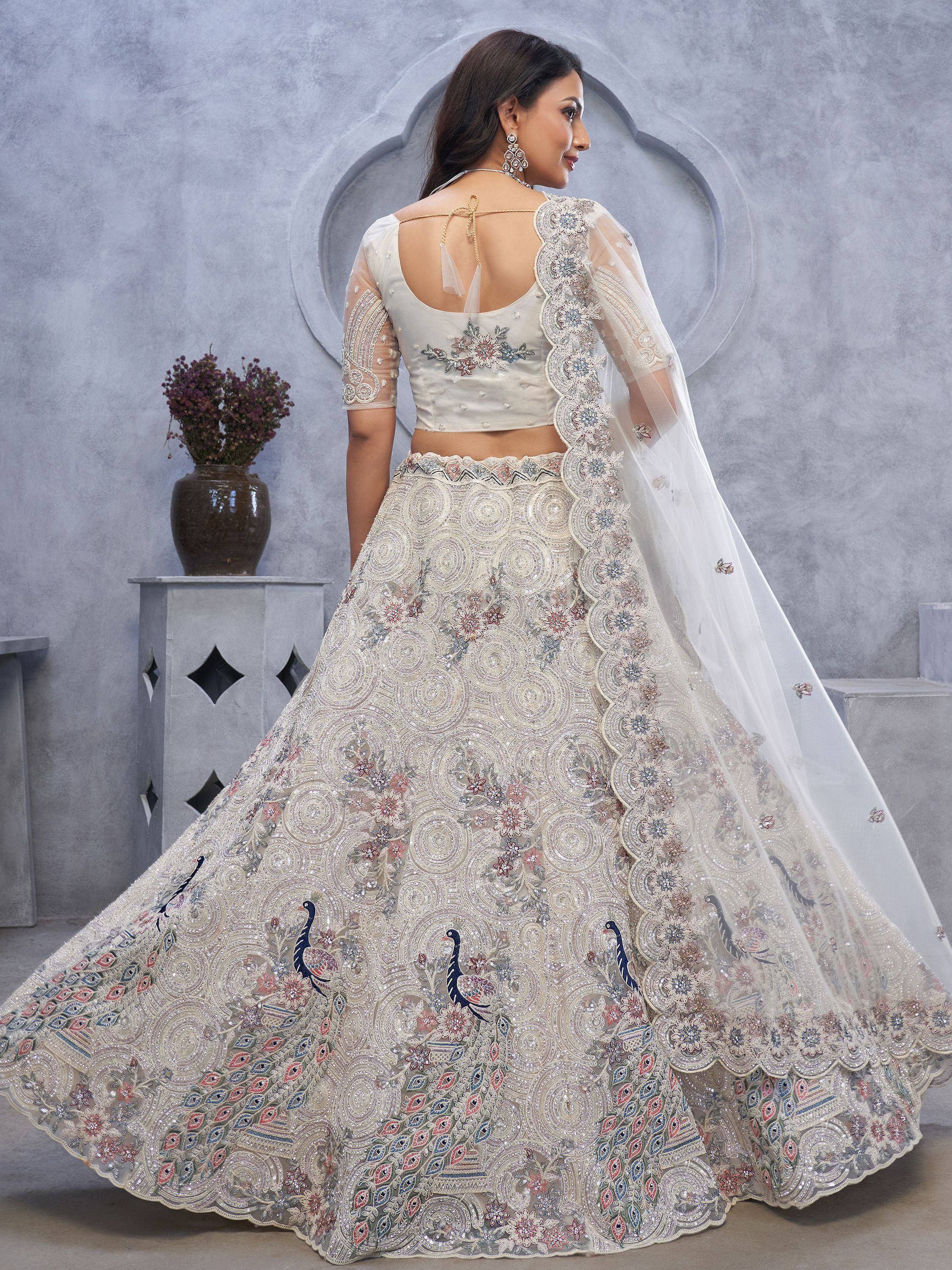 Elegant ivory lehenga choli with peacock embroidery, floral motifs, and sheer dupatta for Indian weddings