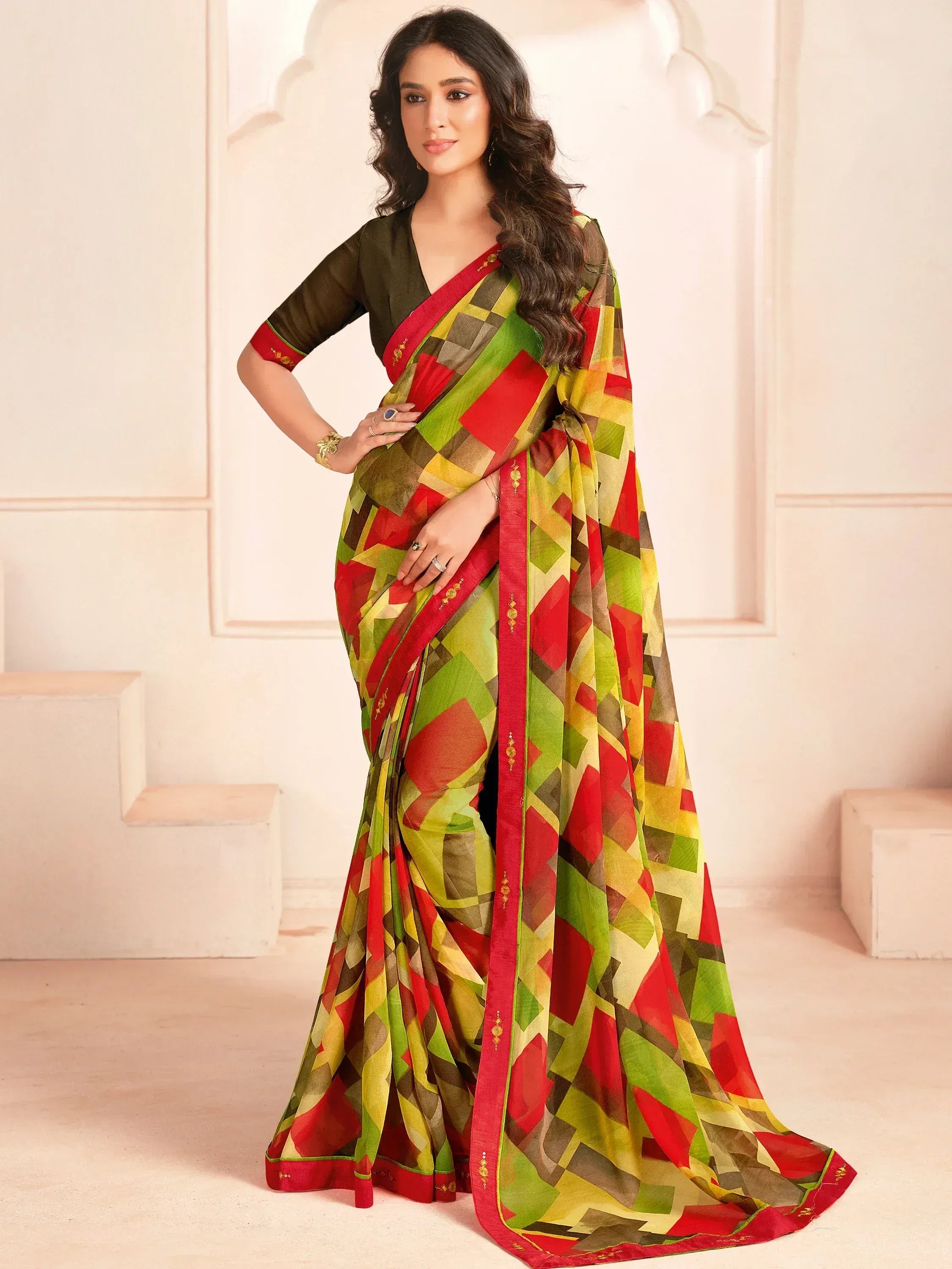 Woman in vibrant geometric print saree with red border, paired with olive blouse, ideal for ethnic occasions