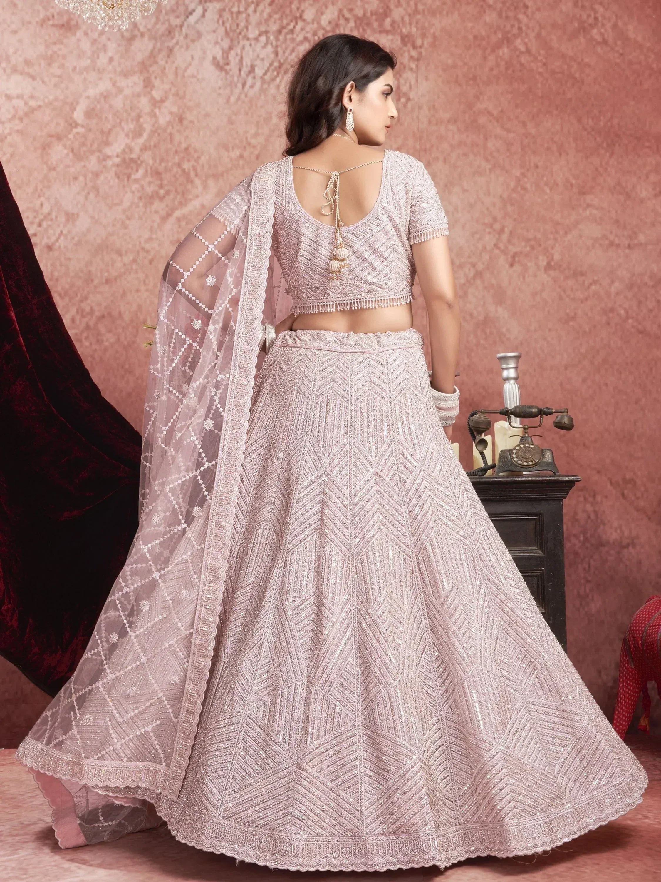 Elegant blush pink designer lehenga choli with intricate embroidery and sheer dupatta, perfect for weddings
