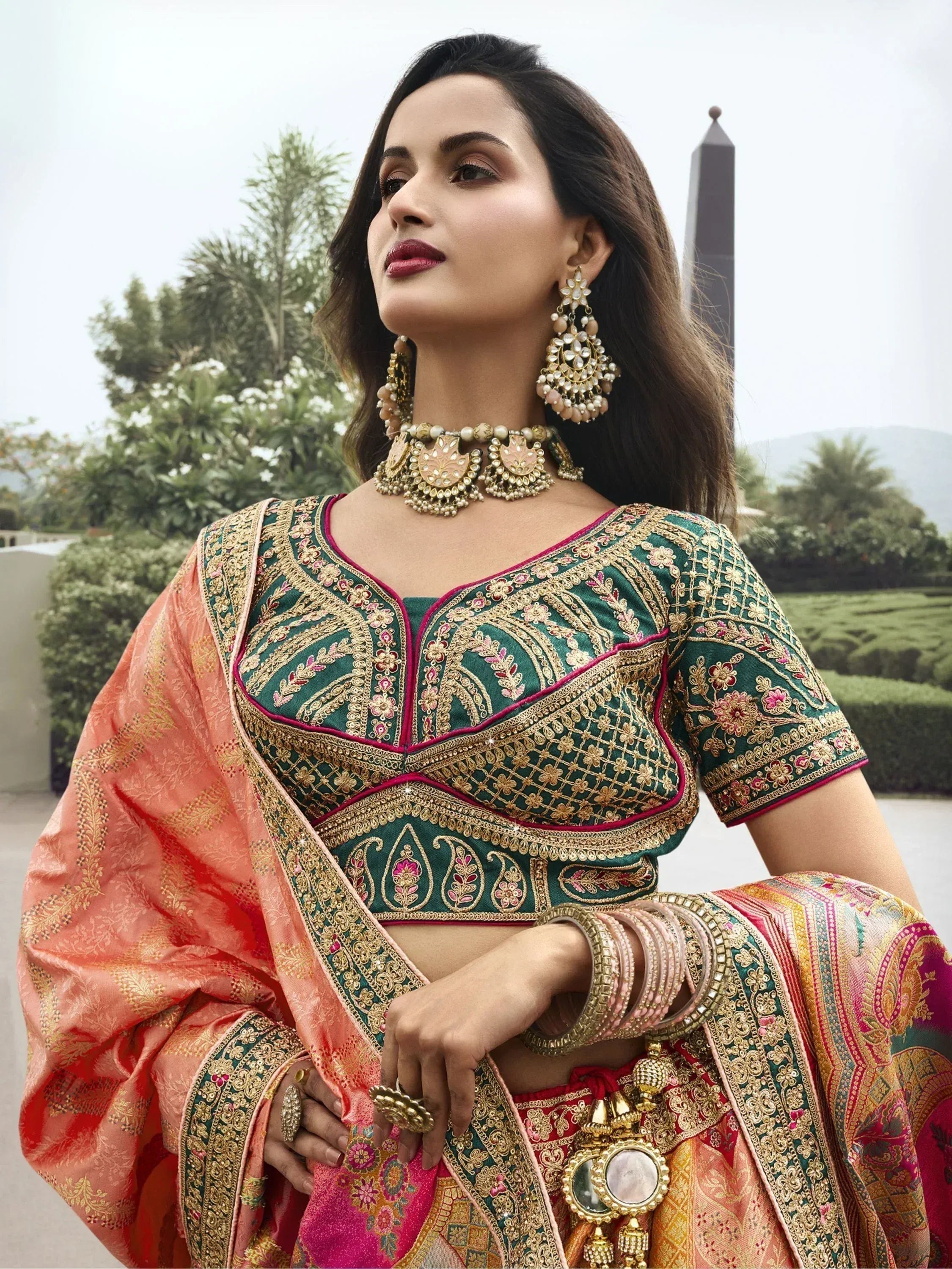 Elegant green and peach designer lehenga choli with heavy gold embroidery and traditional jewelry