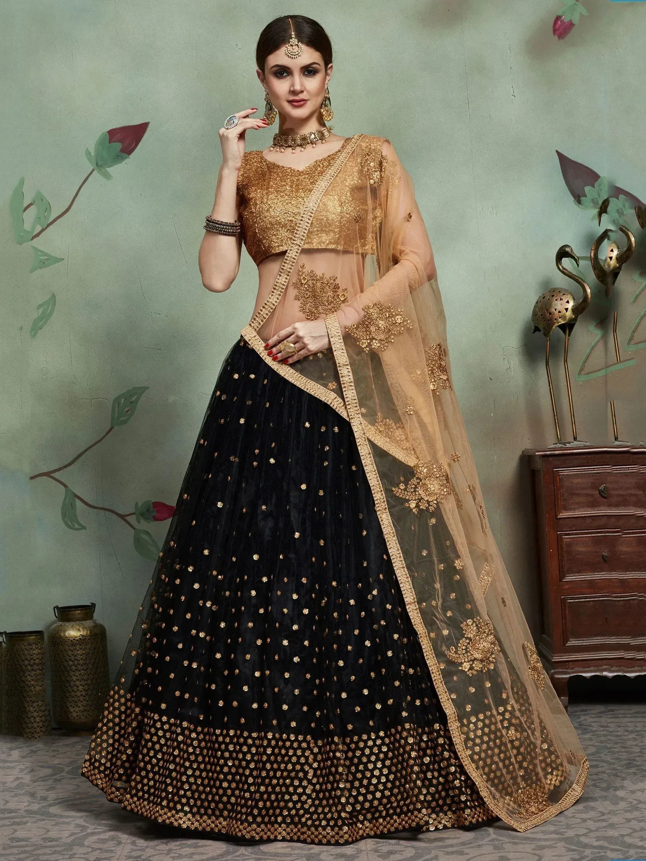 Black and gold embroidered lehenga choli with sheer dupatta, perfect for Indian weddings and festive occasions.