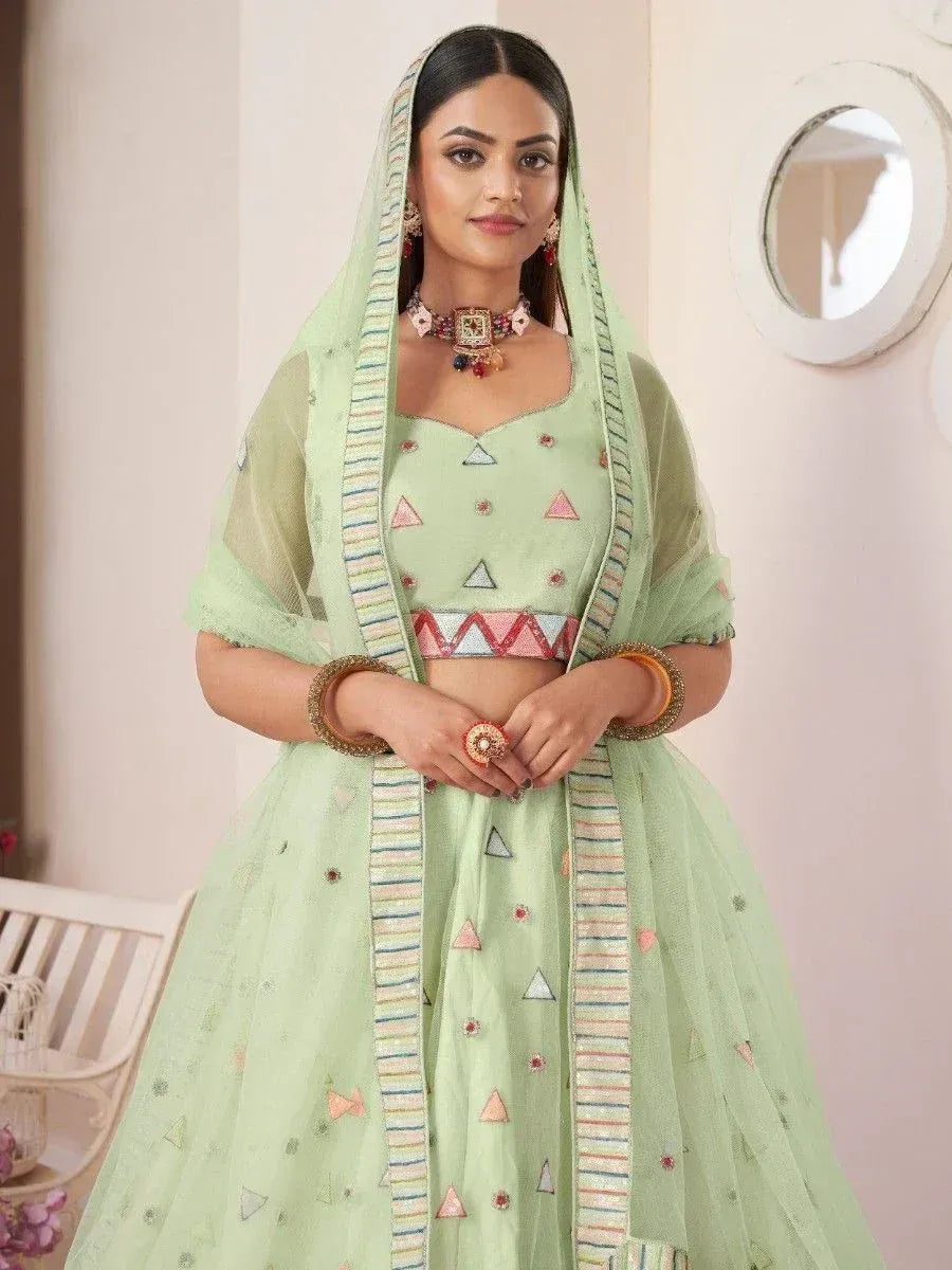 Mint green designer lehenga choli with geometric embroidery and matching dupatta, perfect for Indian ethnic occasions.