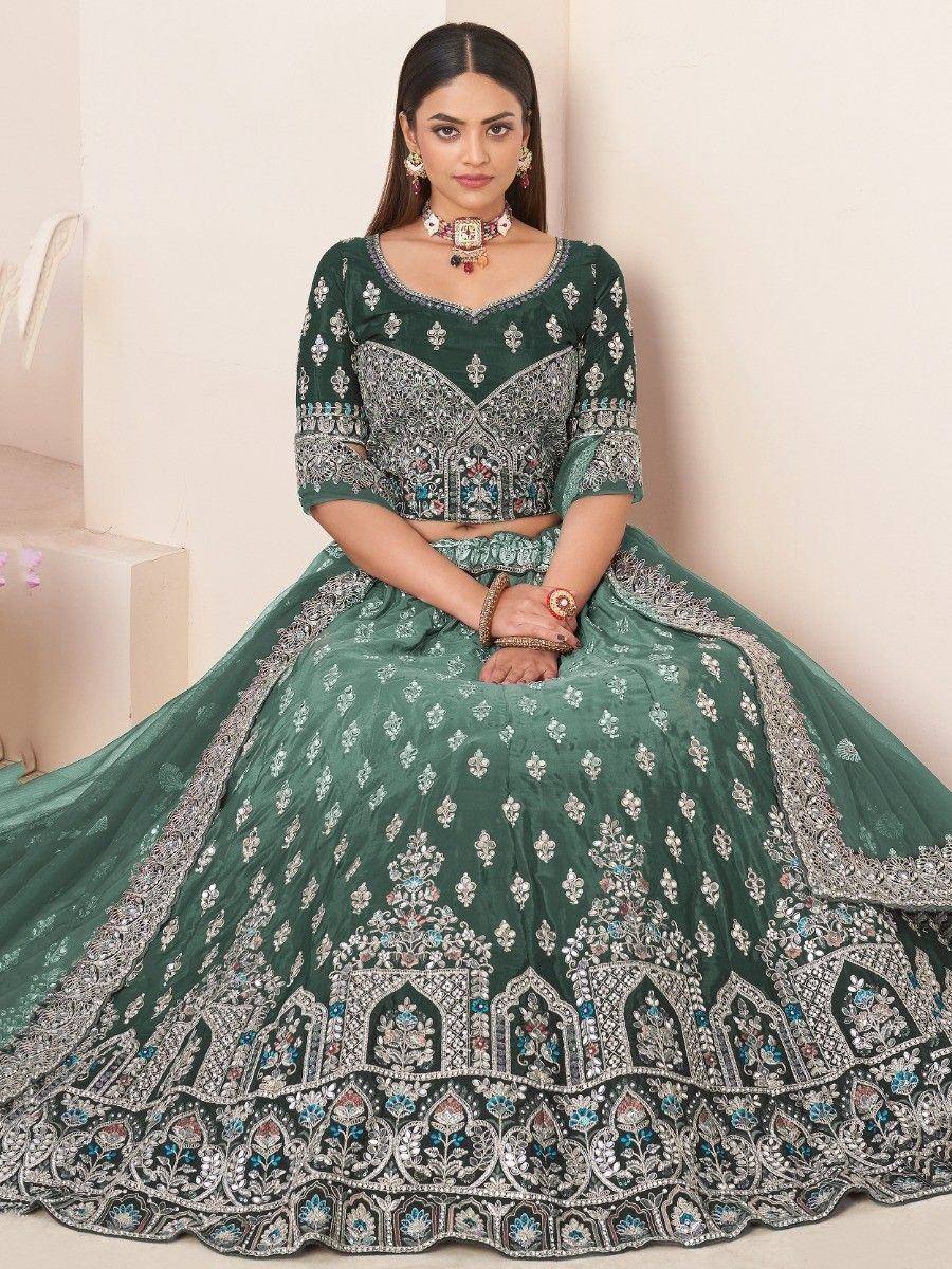 Emerald green designer lehenga choli with heavy silver embroidery and floral motifs, perfect for weddings.