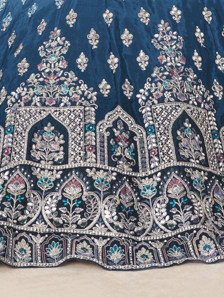 Blue velvet lehenga with intricate floral embroidery and mirror work, perfect for Indian ethnic wear.