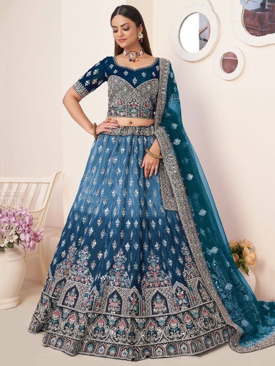 Blue embroidered lehenga choli with heavy embellishments and matching dupatta, perfect for Indian weddings and festive occasions.