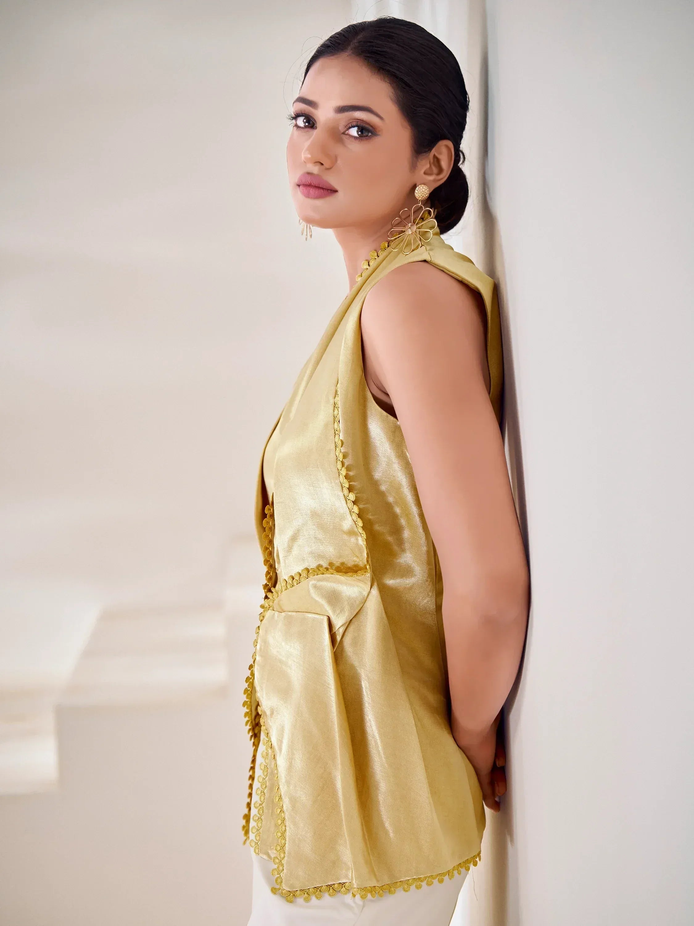Golden sleeveless ethnic top with scalloped detailing and floral earrings