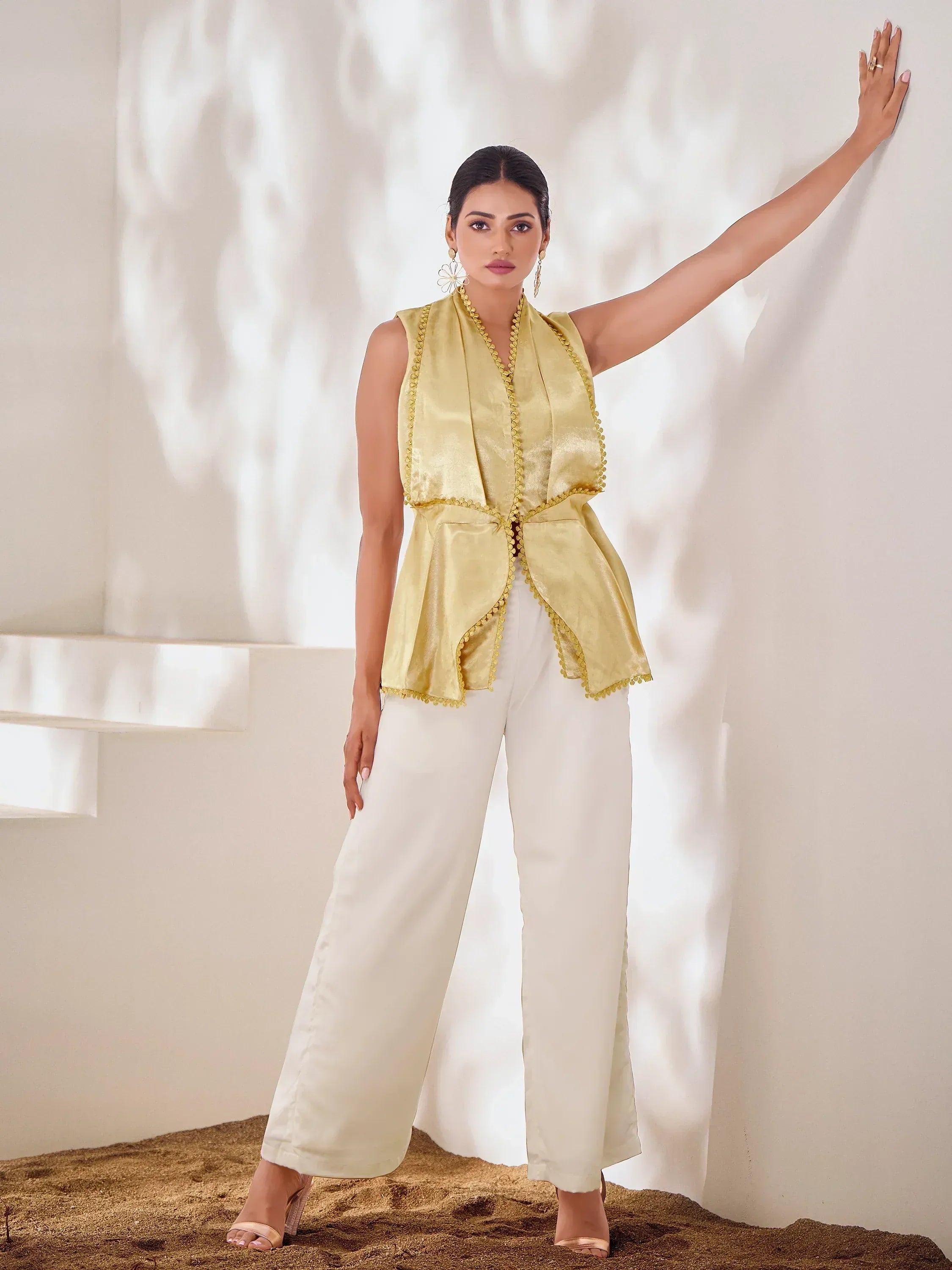 Yellow sleeveless ethnic top with pom trim paired with white palazzo pants, stylish Indian wear