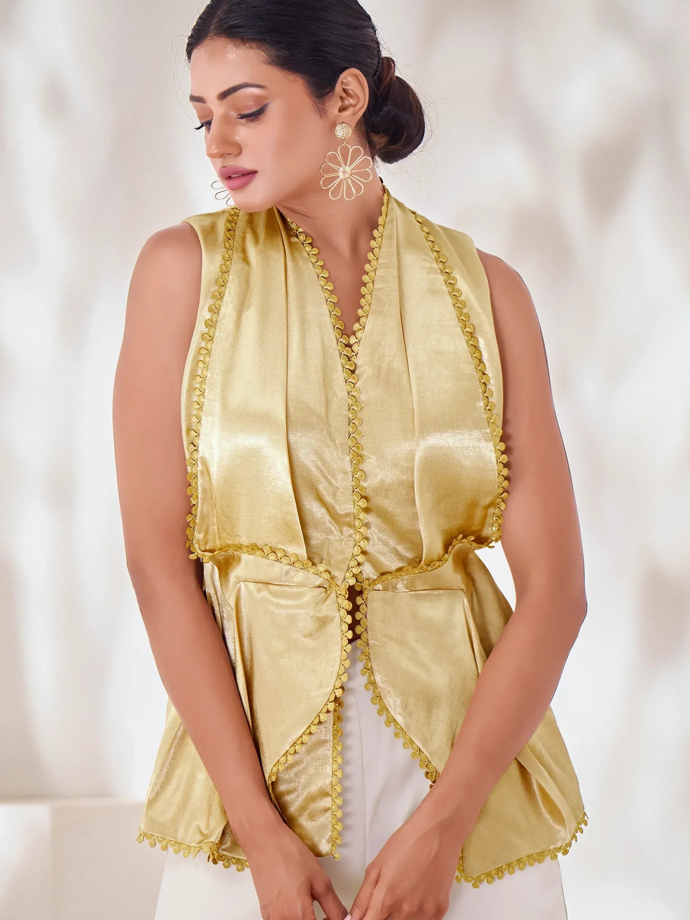 Golden sleeveless ethnic top with scalloped trim, paired with white pants for festive occasions
