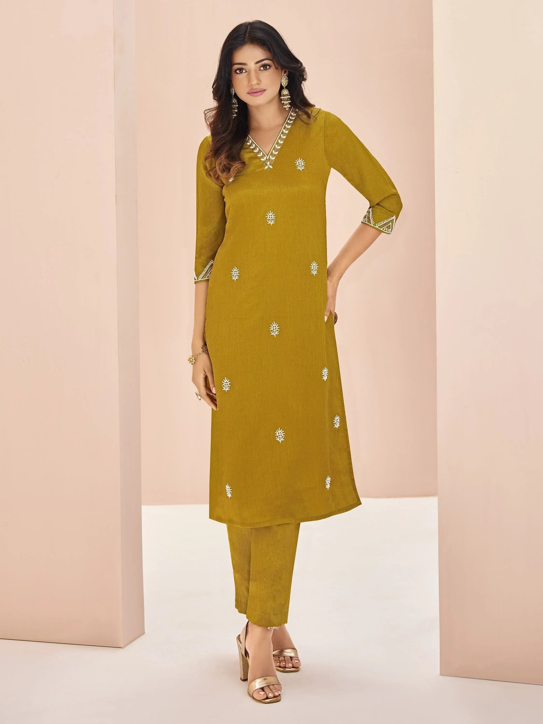 Woman in mustard yellow straight cut salwar kameez with embroidery and block heels