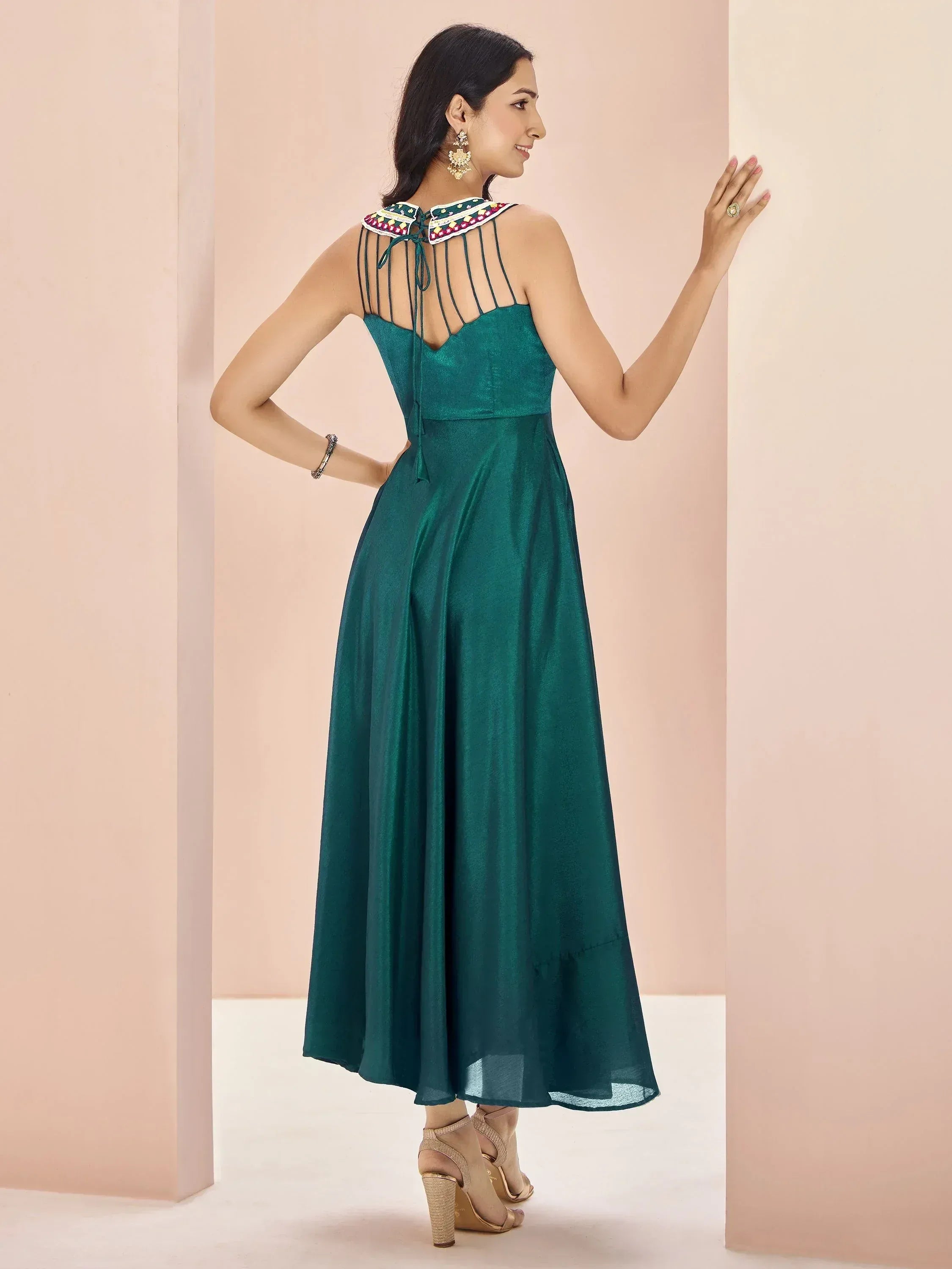 Emerald green ethnic gown with embroidered back detailing and strappy design, perfect for Indian occasions