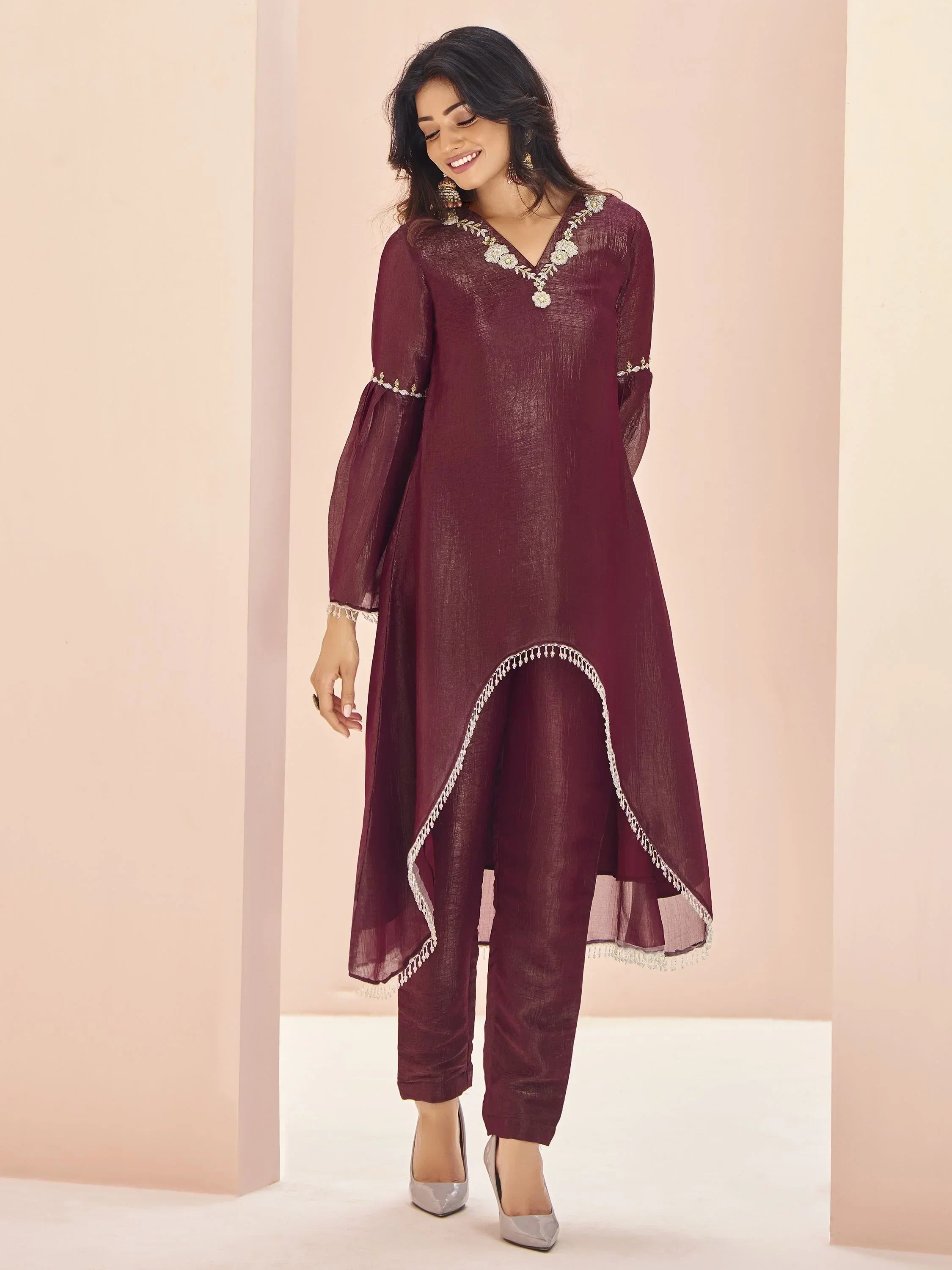 Woman in maroon embroidered ethnic kurta set with straight pants, long sleeves, and silver heels