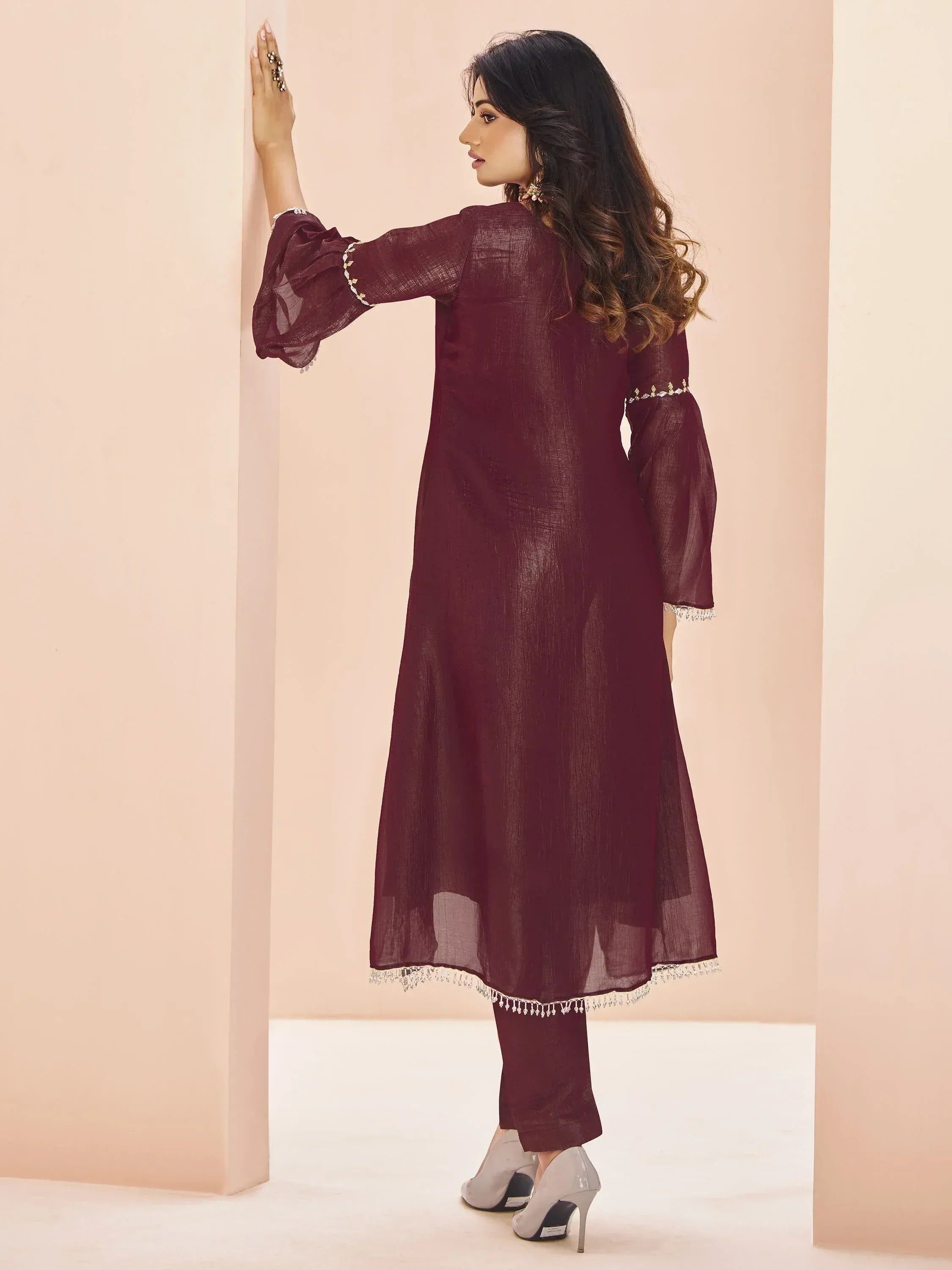 Maroon ethnic kurta with bell sleeves and tassels, paired with matching pants for women
